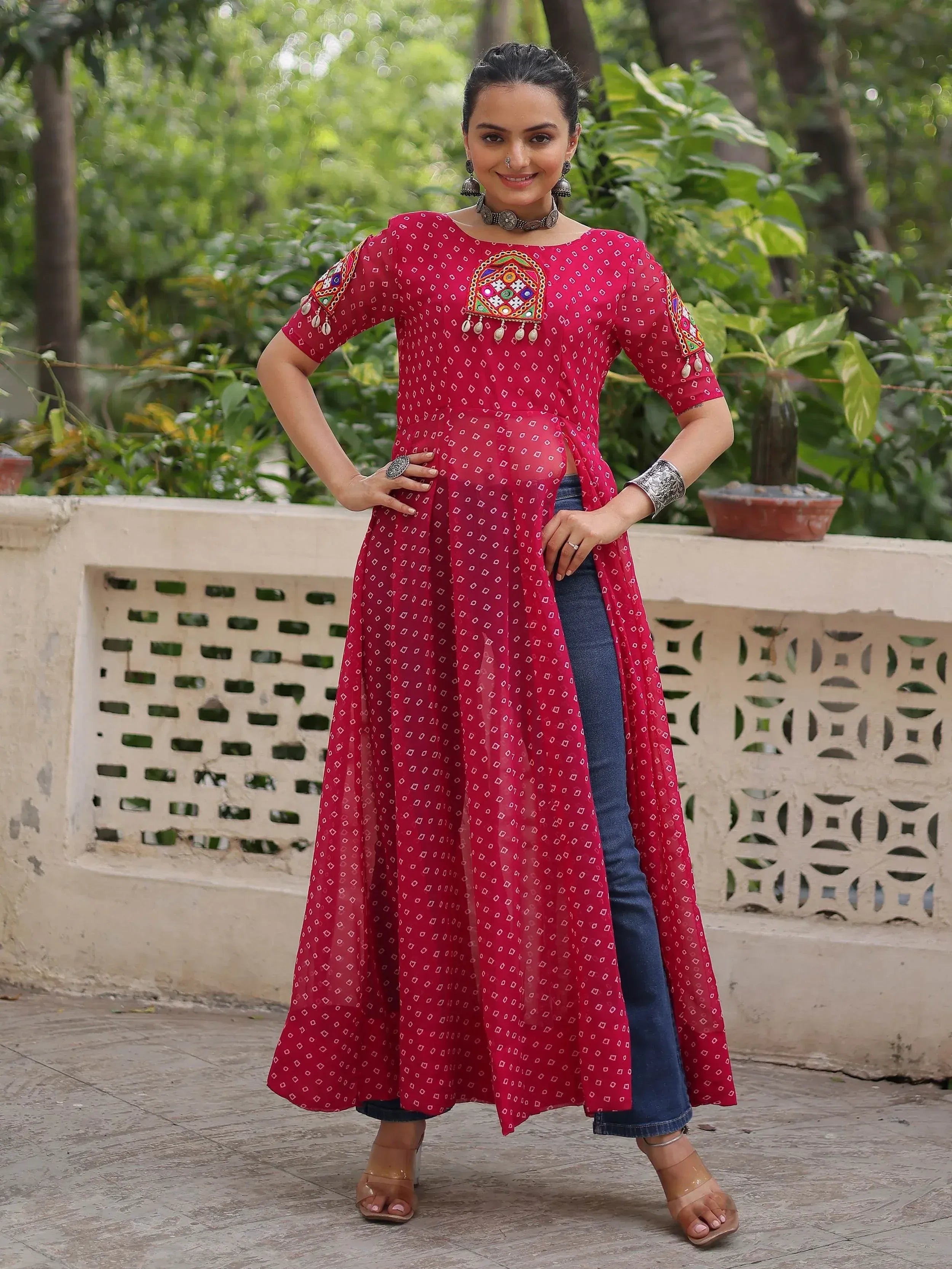 Red embroidered ethnic kurta with mirror work, paired with jeans, for women's Indian wear