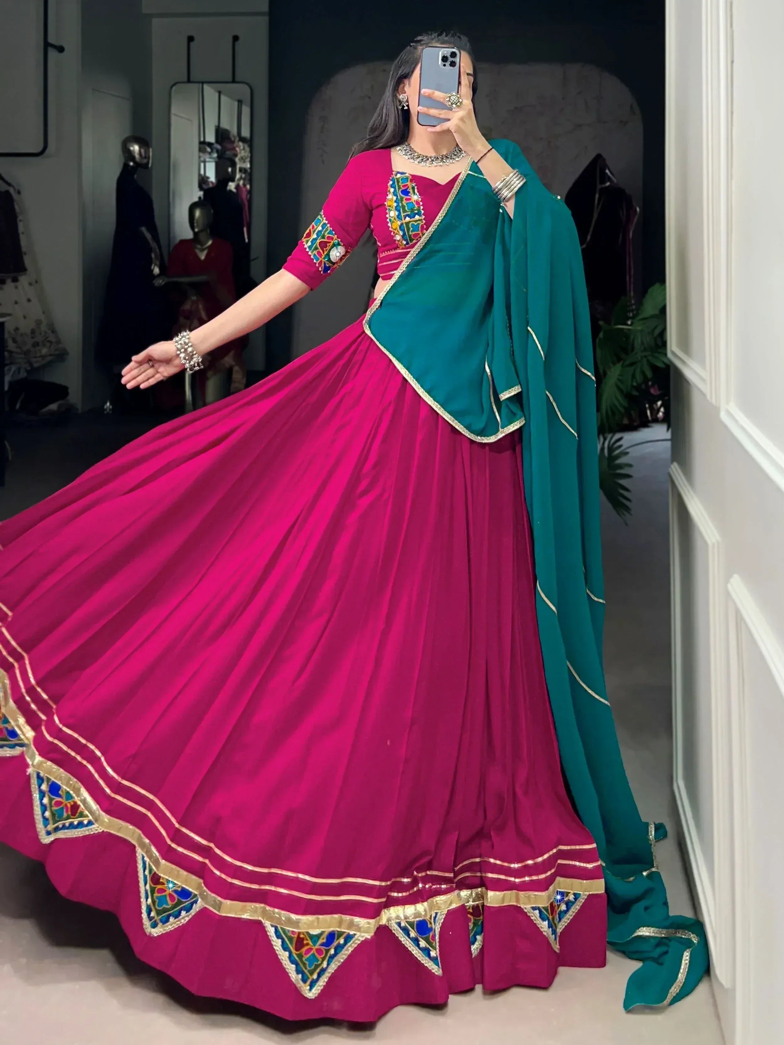 Fuchsia lehenga choli with teal dupatta, colorful mirror work, and gold trim for Indian ethnic wear