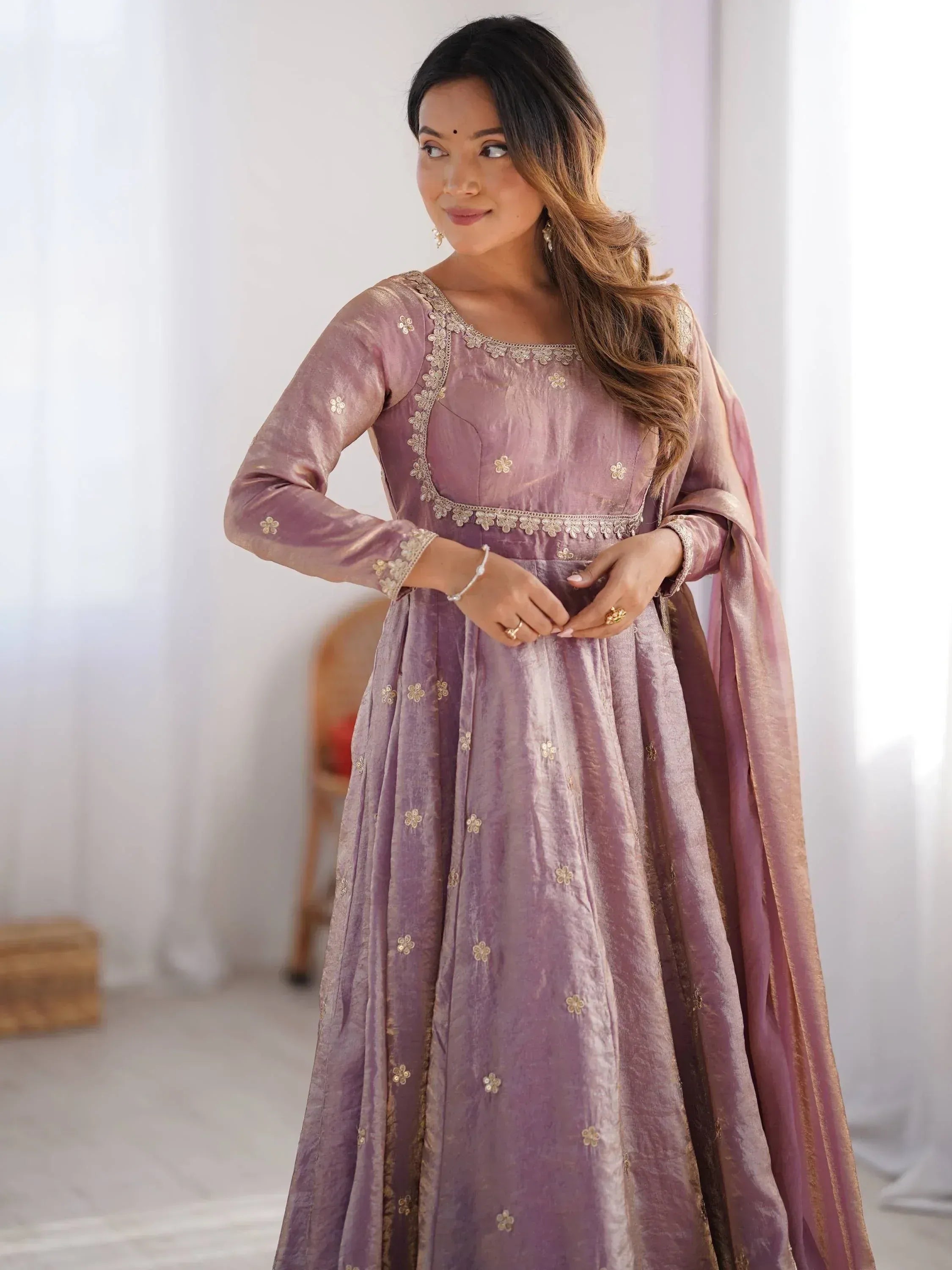 Woman in elegant mauve velvet anarkali with gold floral embroidery, perfect for Indian ethnic occasions.