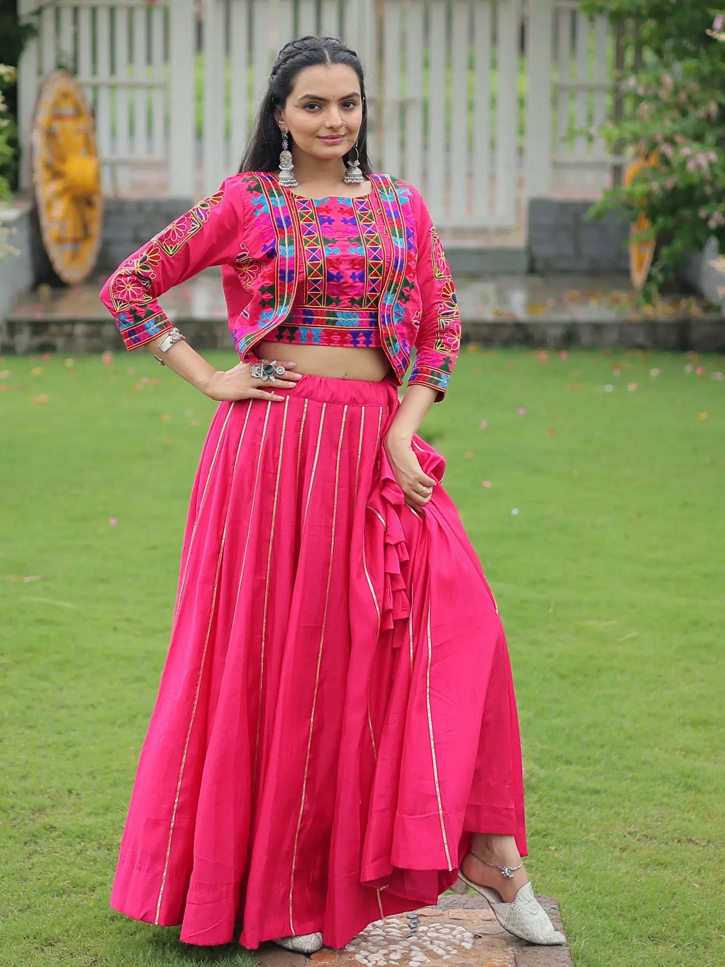 Vibrant pink embroidered lehenga choli with gold stripes, perfect for Indian ethnic wear