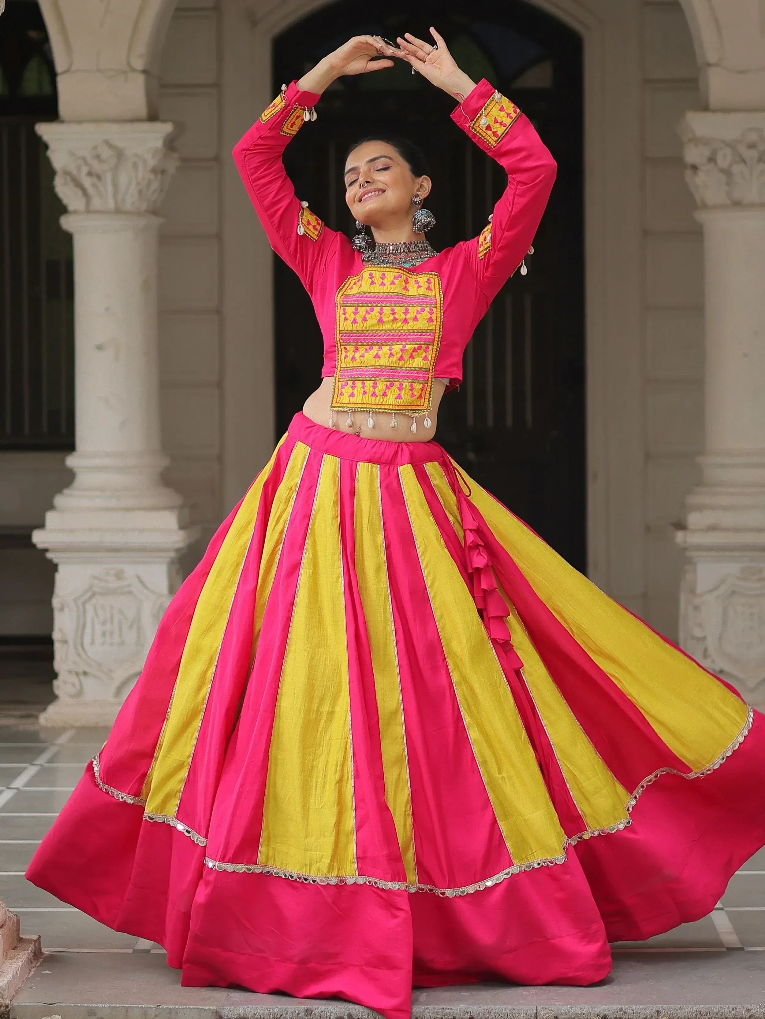 Vibrant pink and yellow lehenga choli with intricate embroidery, perfect for Indian ethnic wear.
