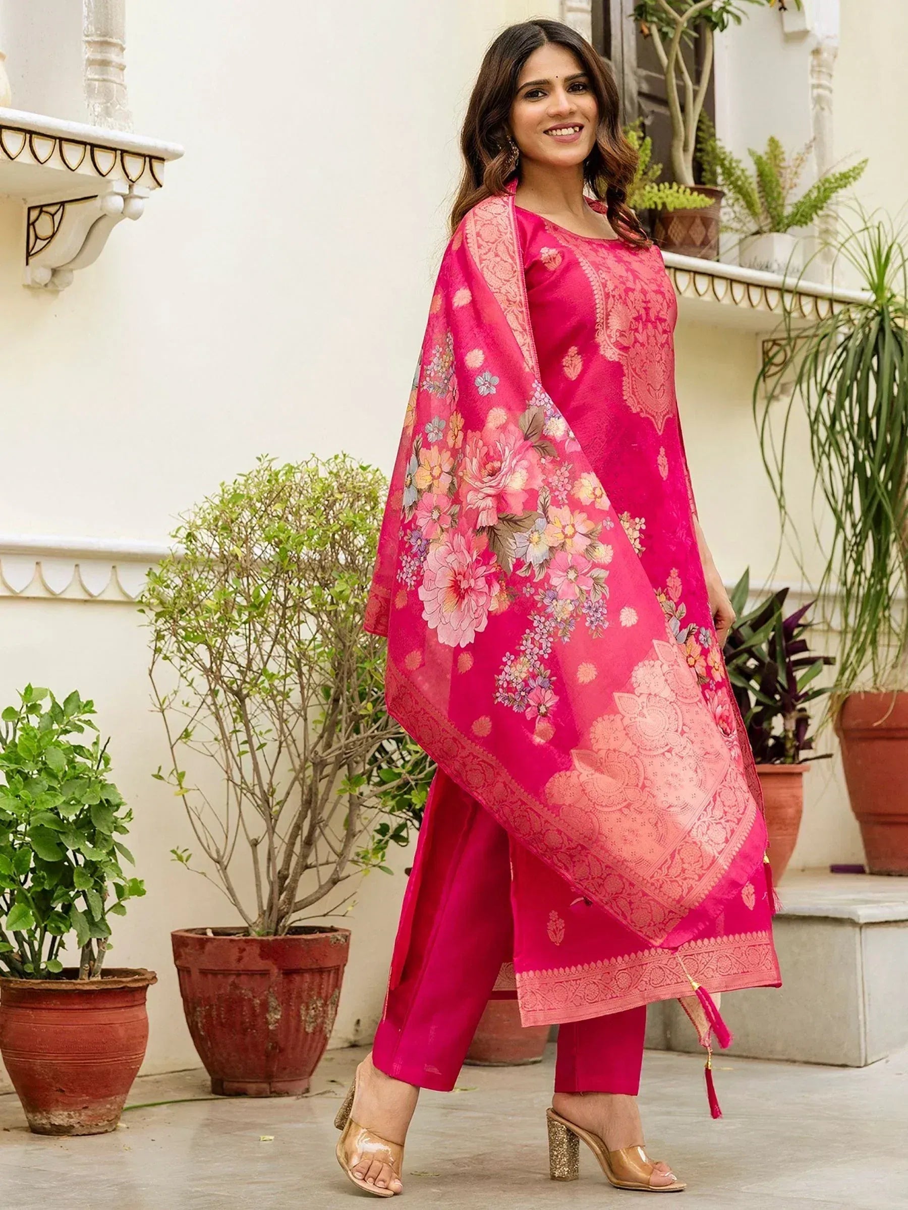 Woman in vibrant pink floral salwar kameez with embroidered dupatta, perfect for Indian ethnic occasions