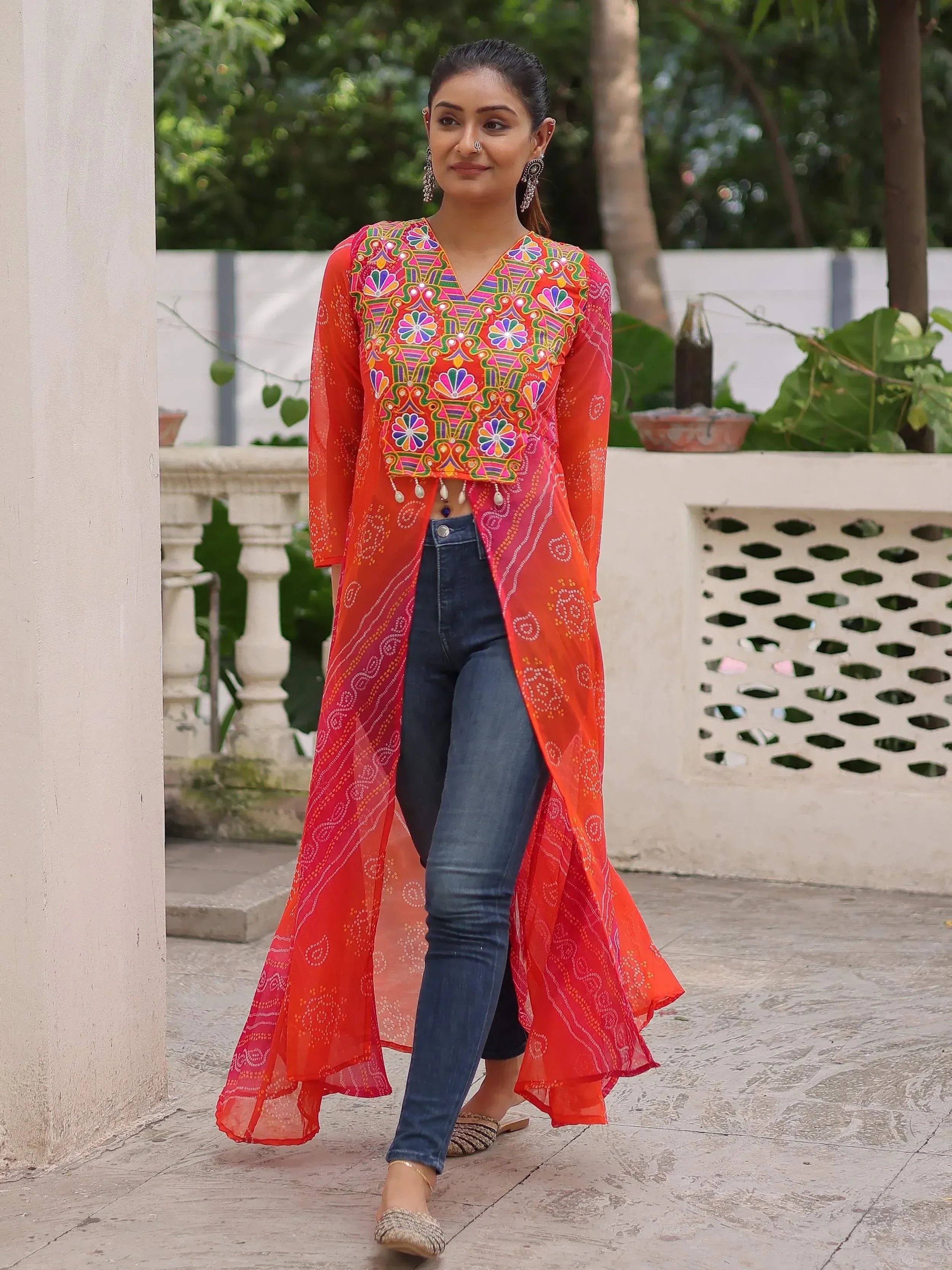 Vibrant orange embroidered ethnic kurta with sheer overlay, paired with jeans for fusion style