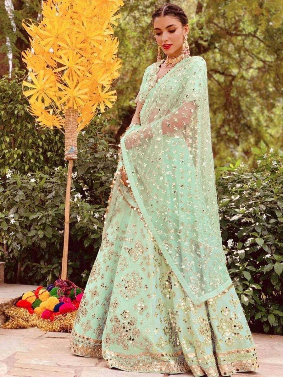Mint green designer lehenga choli with gold embroidery, perfect for Indian weddings and festive occasions.