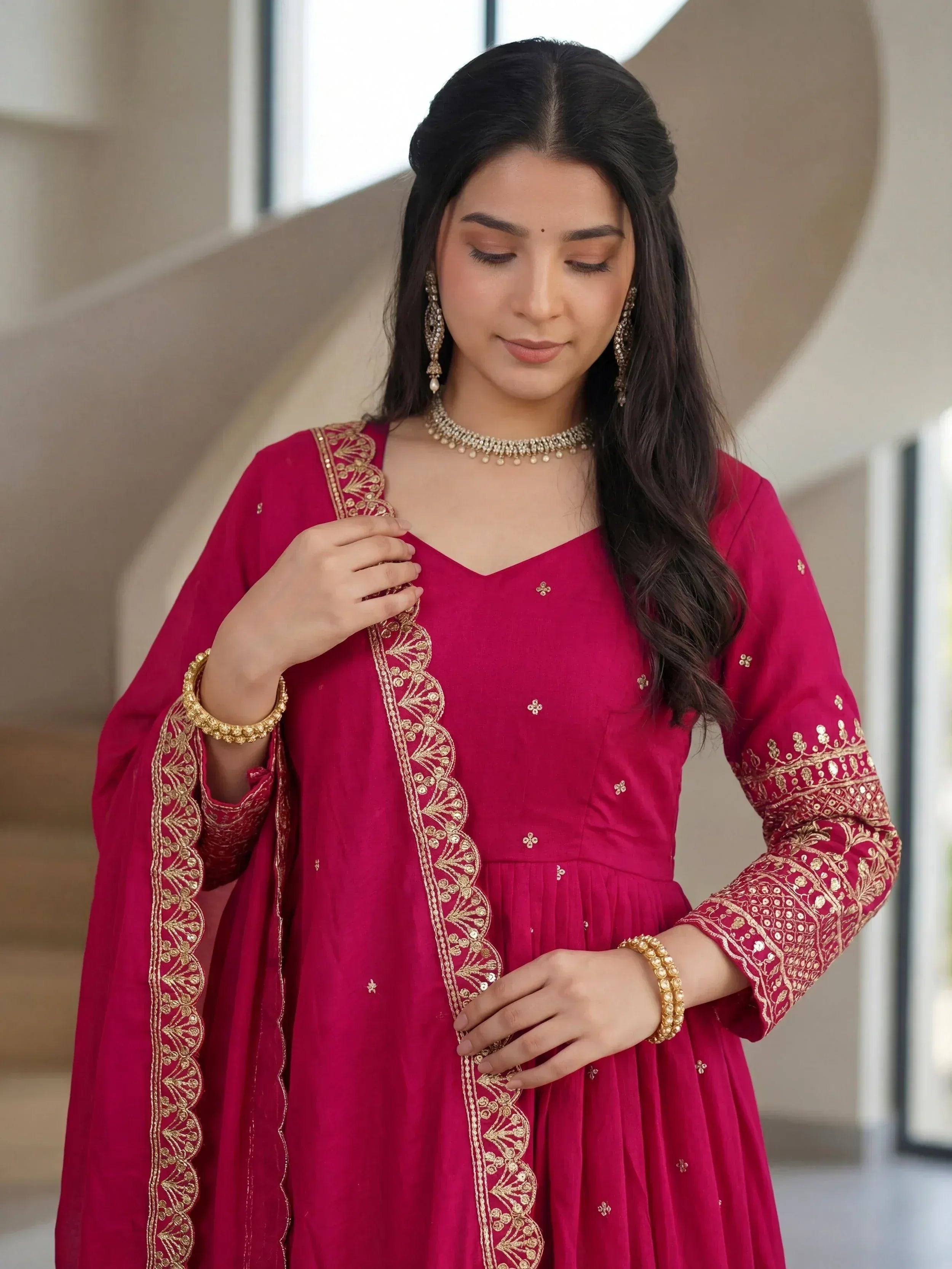 Elegant maroon ethnic gown with gold embroidery, perfect for Indian festive occasions and celebrations.