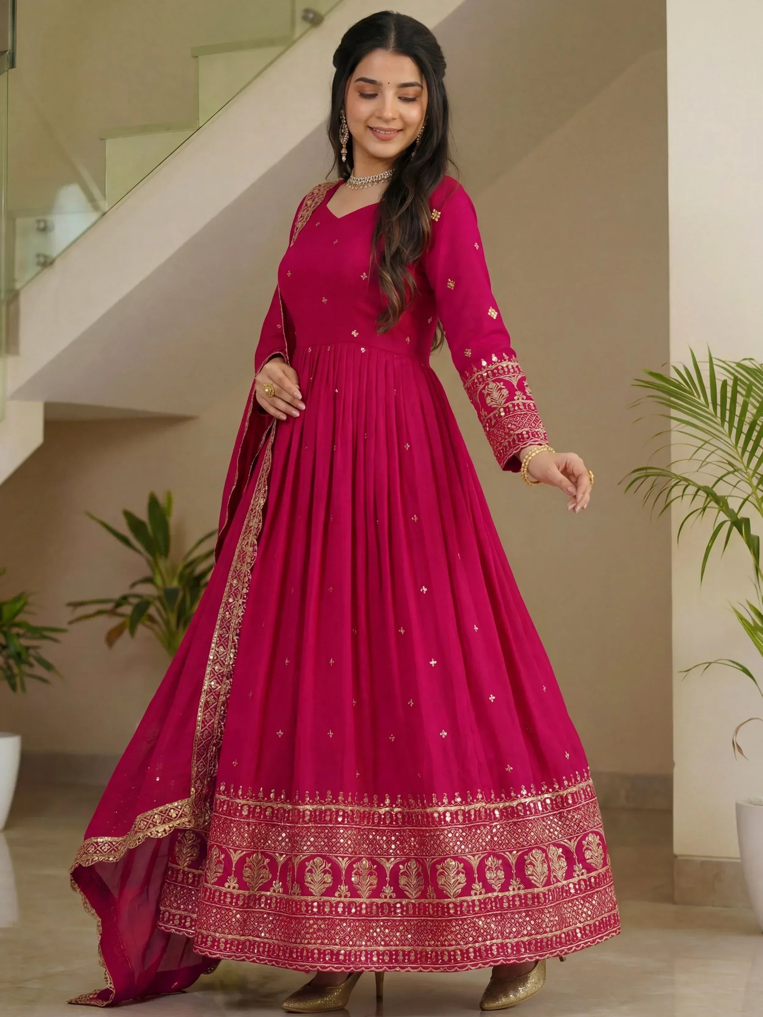 Magenta ethnic gown with gold embroidery, perfect for Indian weddings and festive occasions.