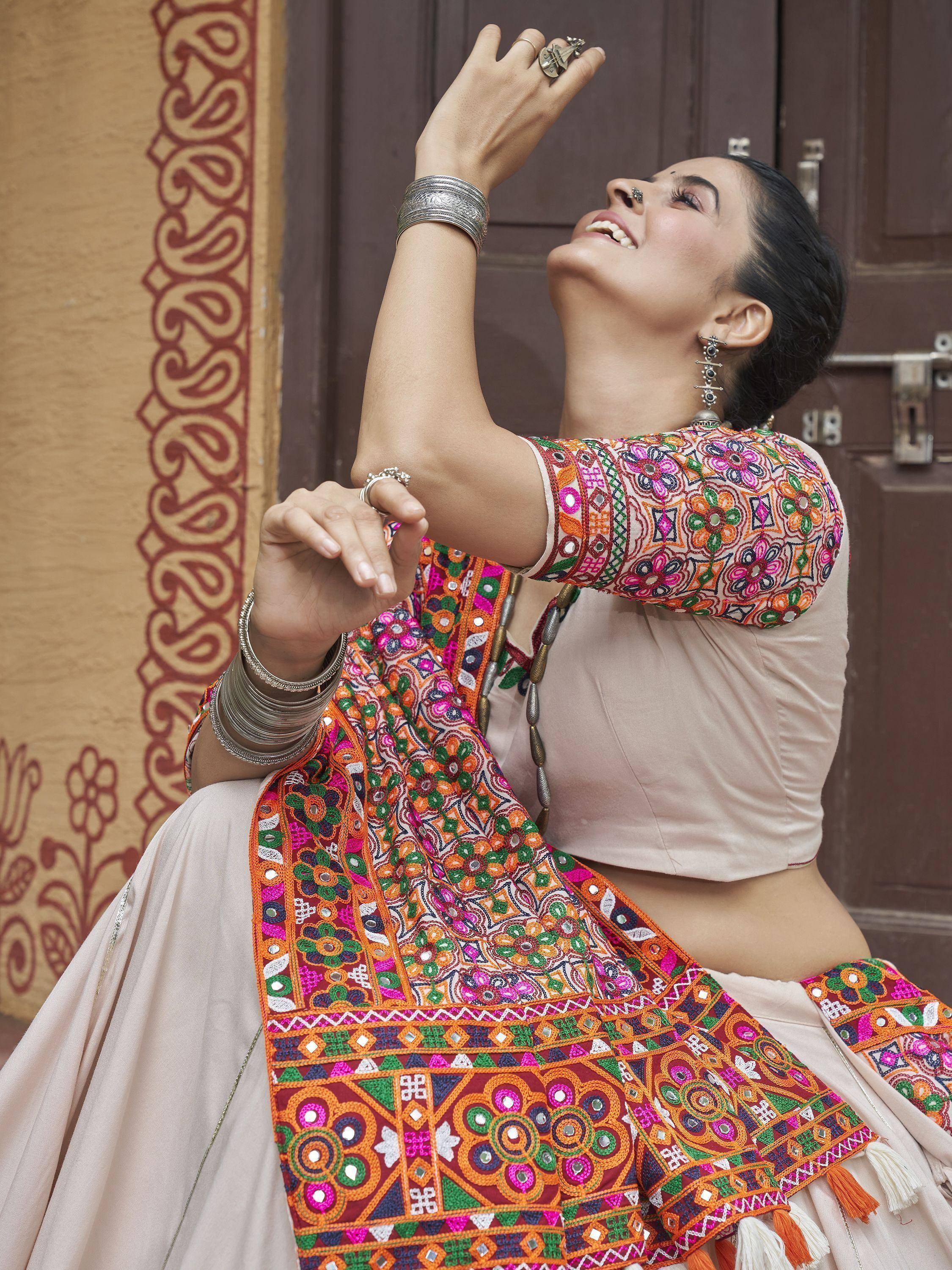 Woman in colorful embroidered Indian ethnic wear with mirror work, silver jewelry, and traditional dupatta