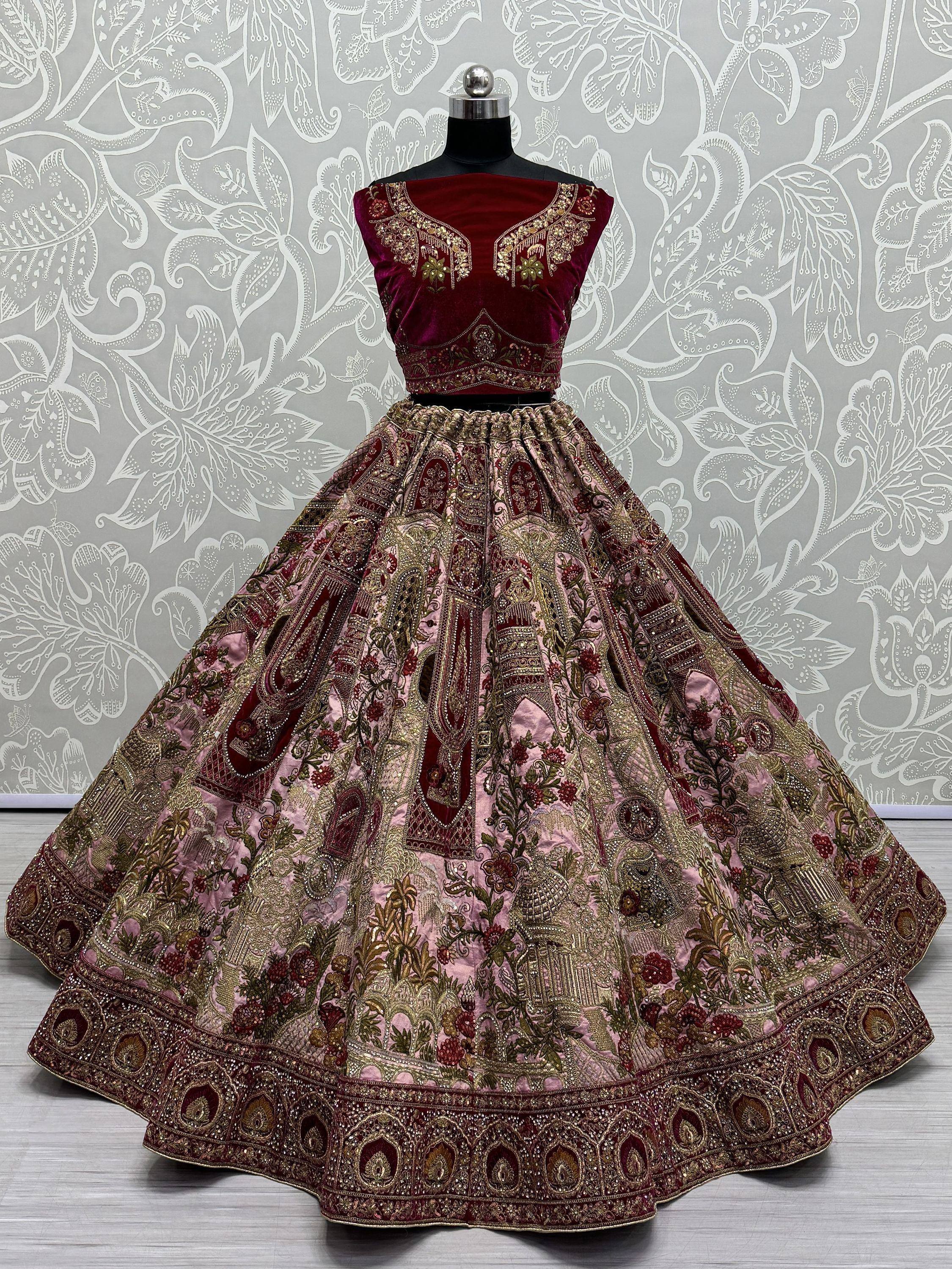 Maroon velvet designer lehenga choli with heavy gold embroidery and floral motifs, perfect for Indian weddings.