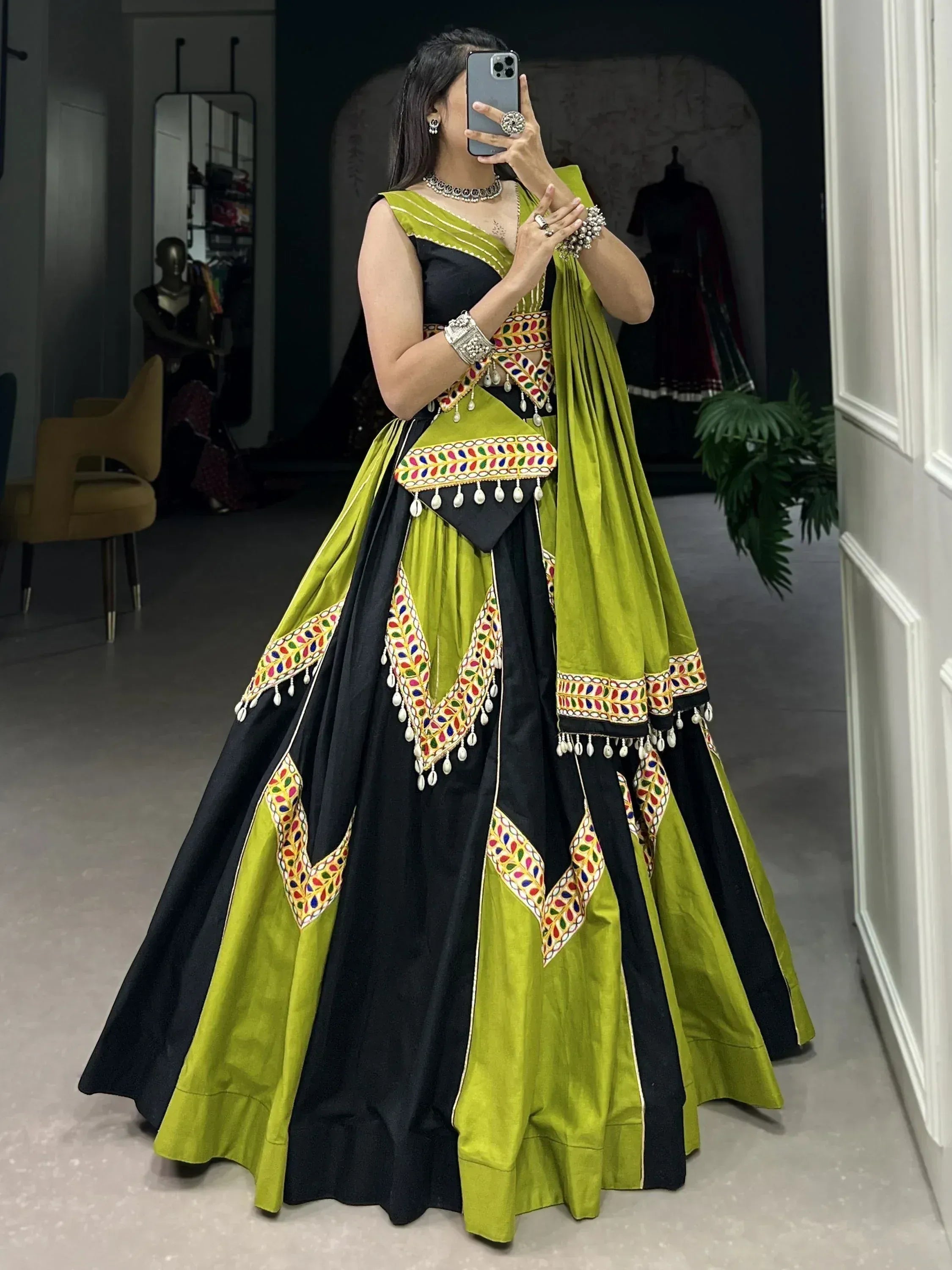 Black and lime green ethnic lehenga choli with mirror work and tassels, perfect for Indian weddings or festive occasions.