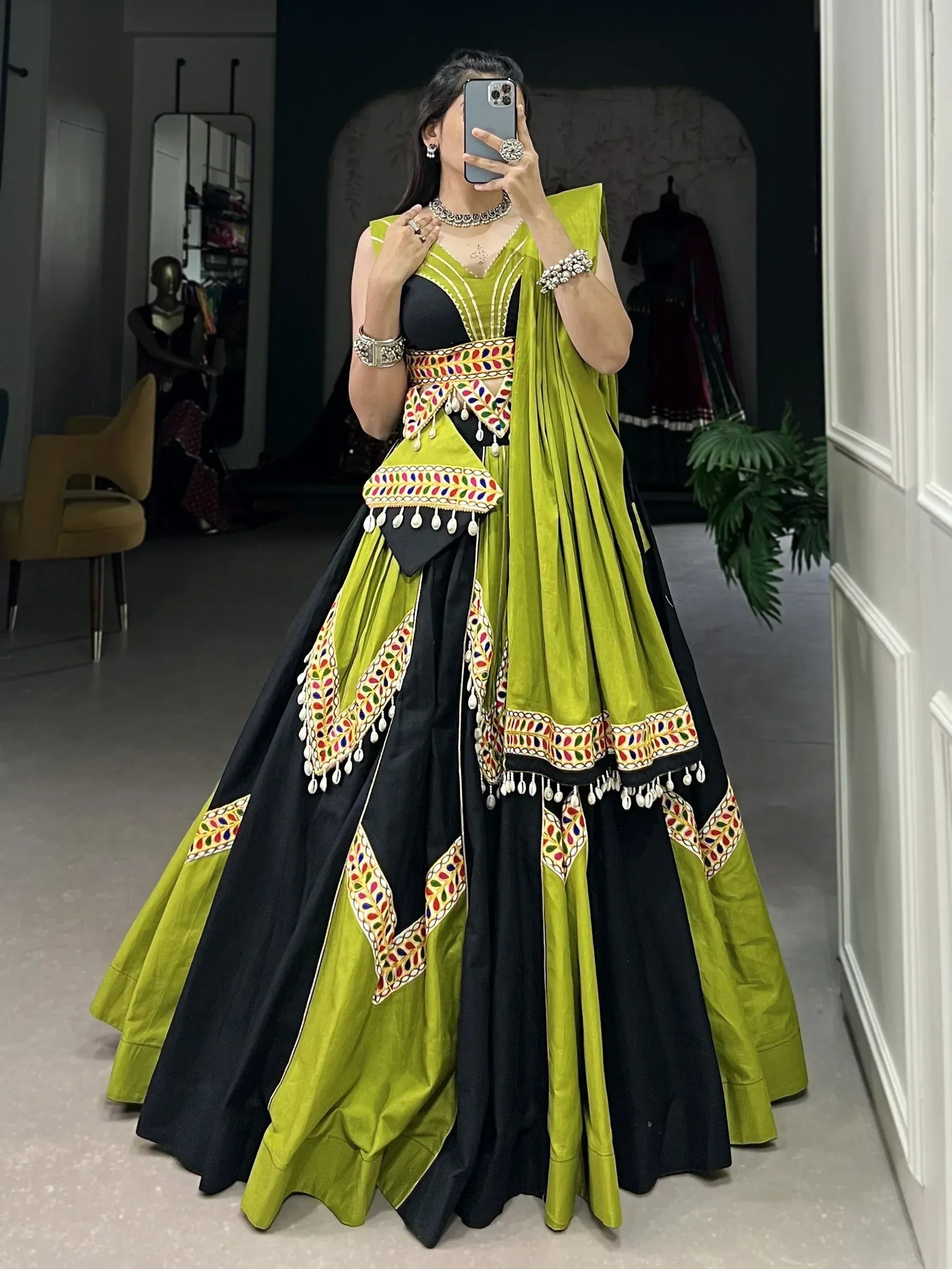 Green and black designer lehenga choli with colorful mirror work and tassels, perfect for Indian ethnic wear.