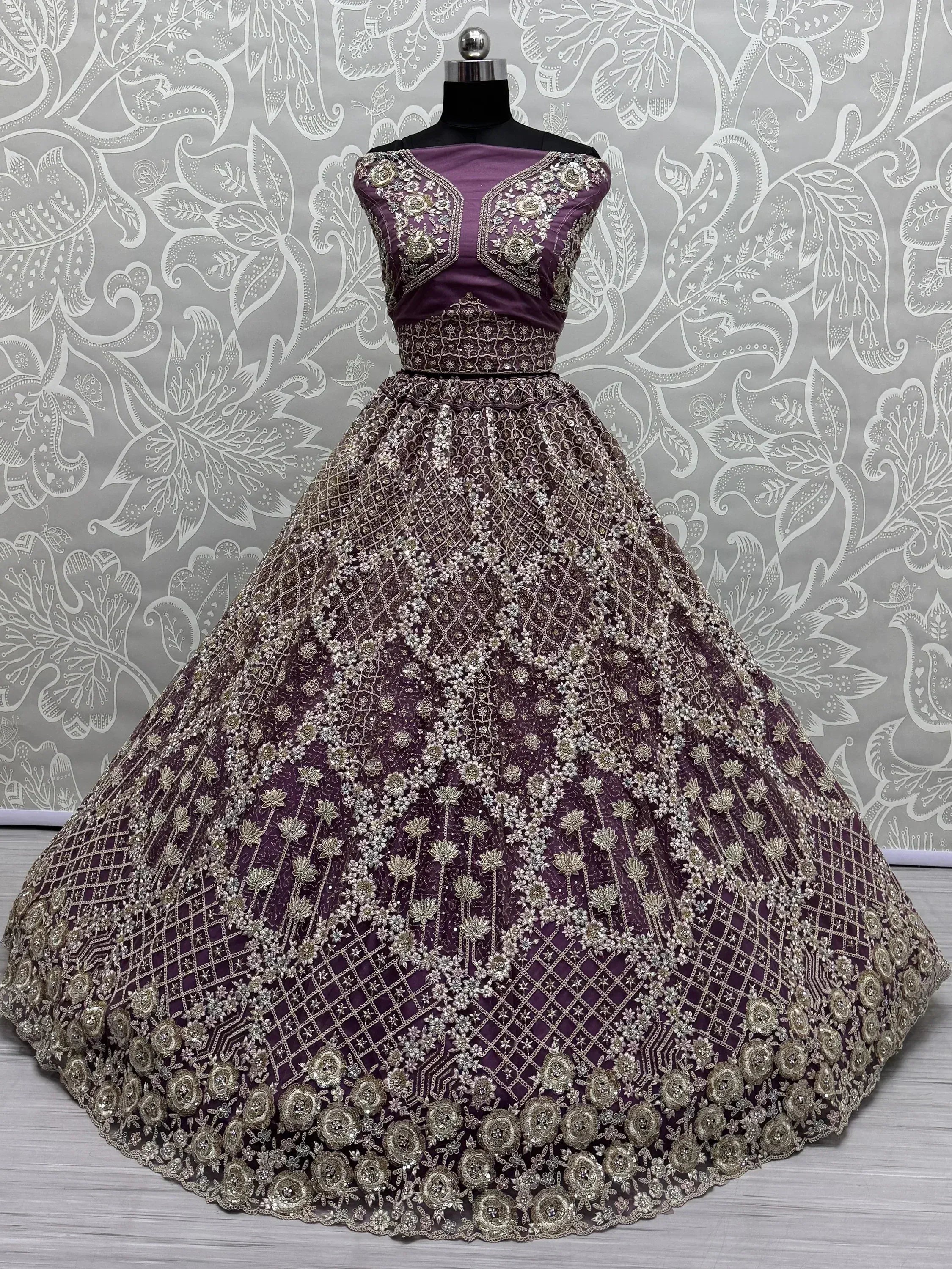 Purple designer lehenga choli with heavy gold embroidery and floral motifs, perfect for weddings and festive occasions.