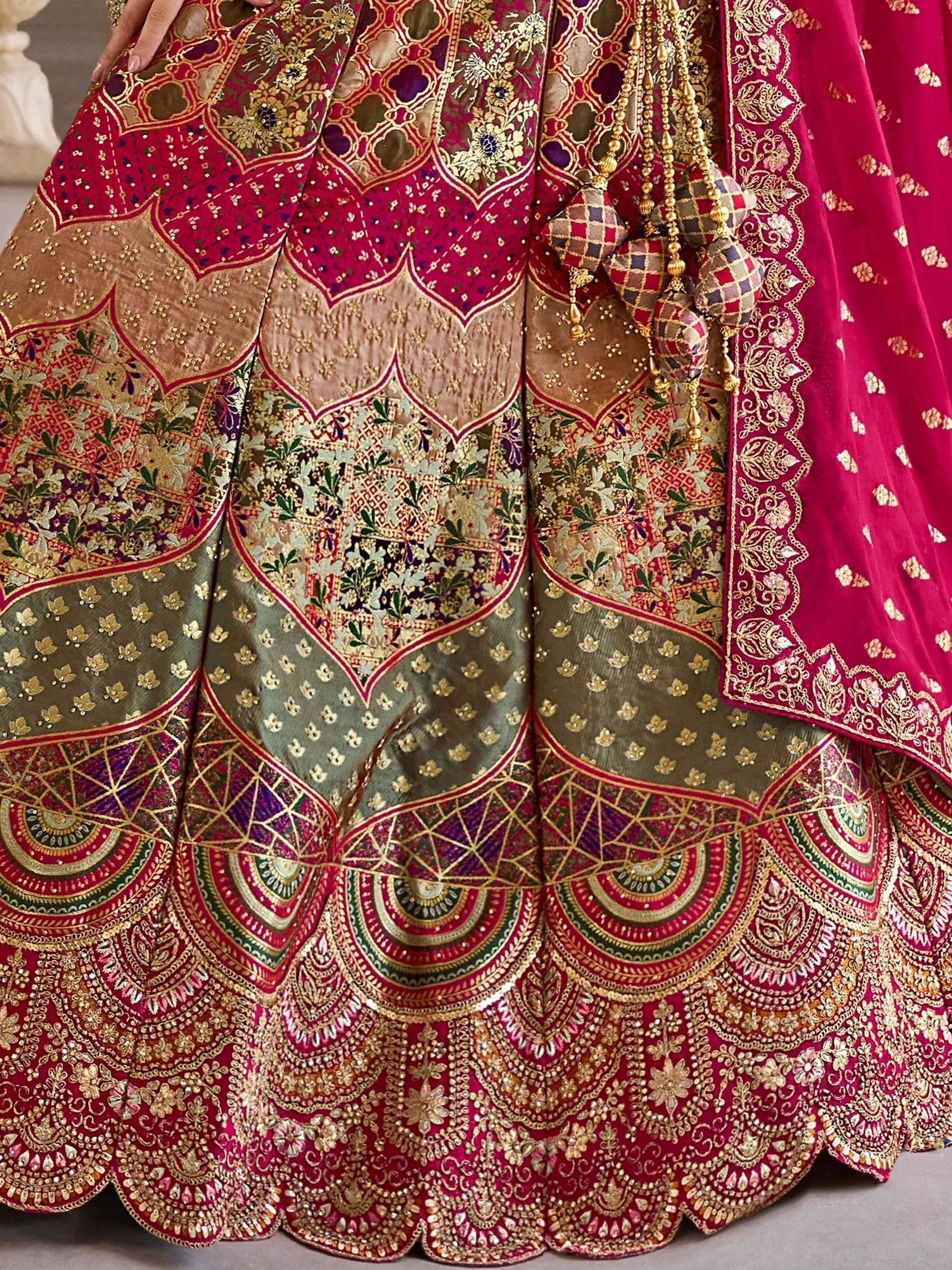 Luxury Indian lehenga choli with intricate gold embroidery, floral patterns, and vibrant red & green hues for weddings