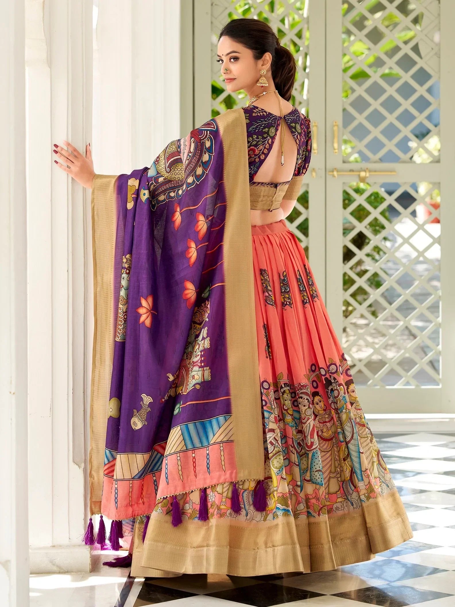 Woman in colorful printed lehenga choli with purple dupatta, ethnic Indian wear for festive occasions