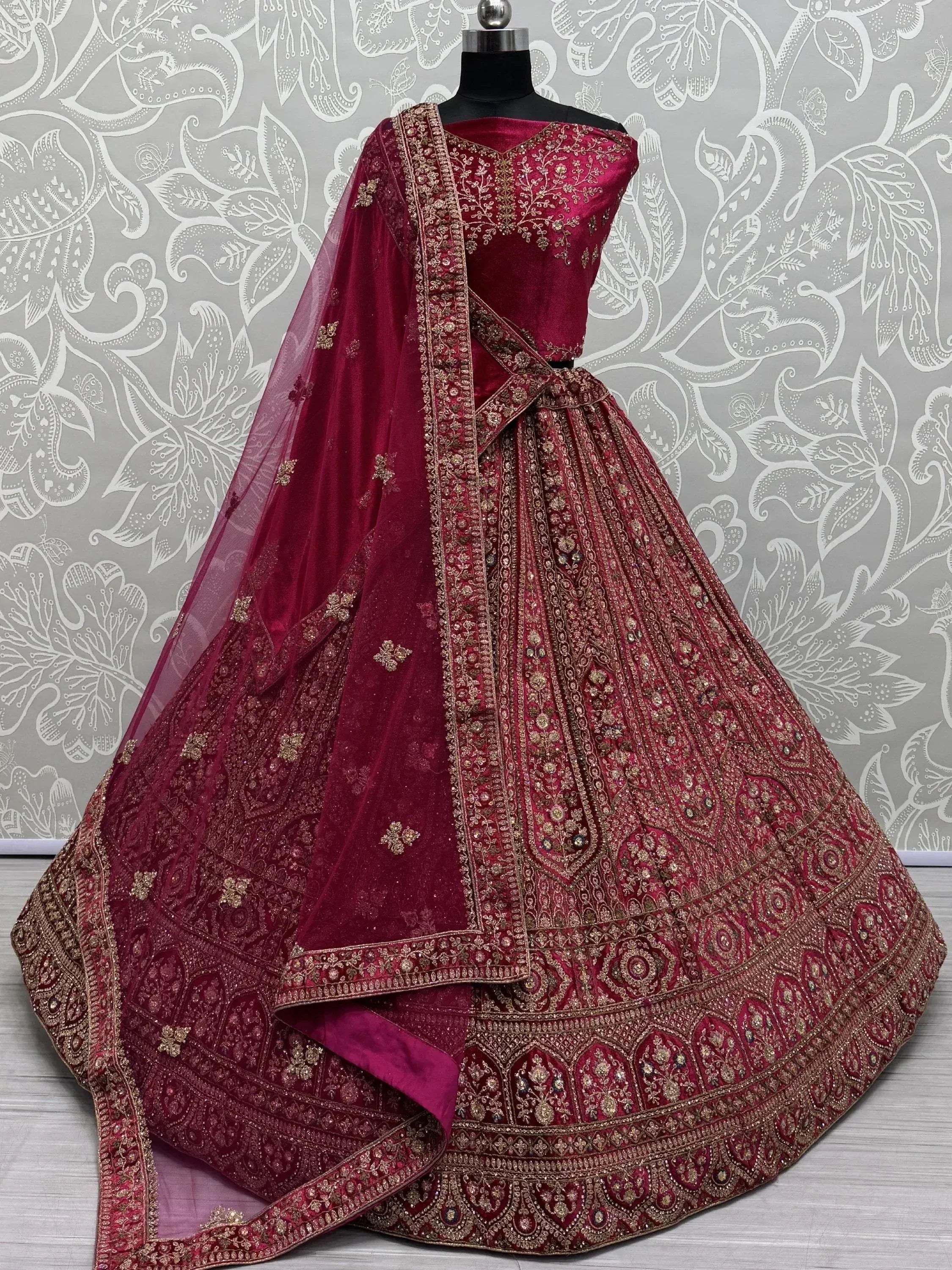 Burgundy velvet designer lehenga choli with gold embroidery and net dupatta, perfect for weddings