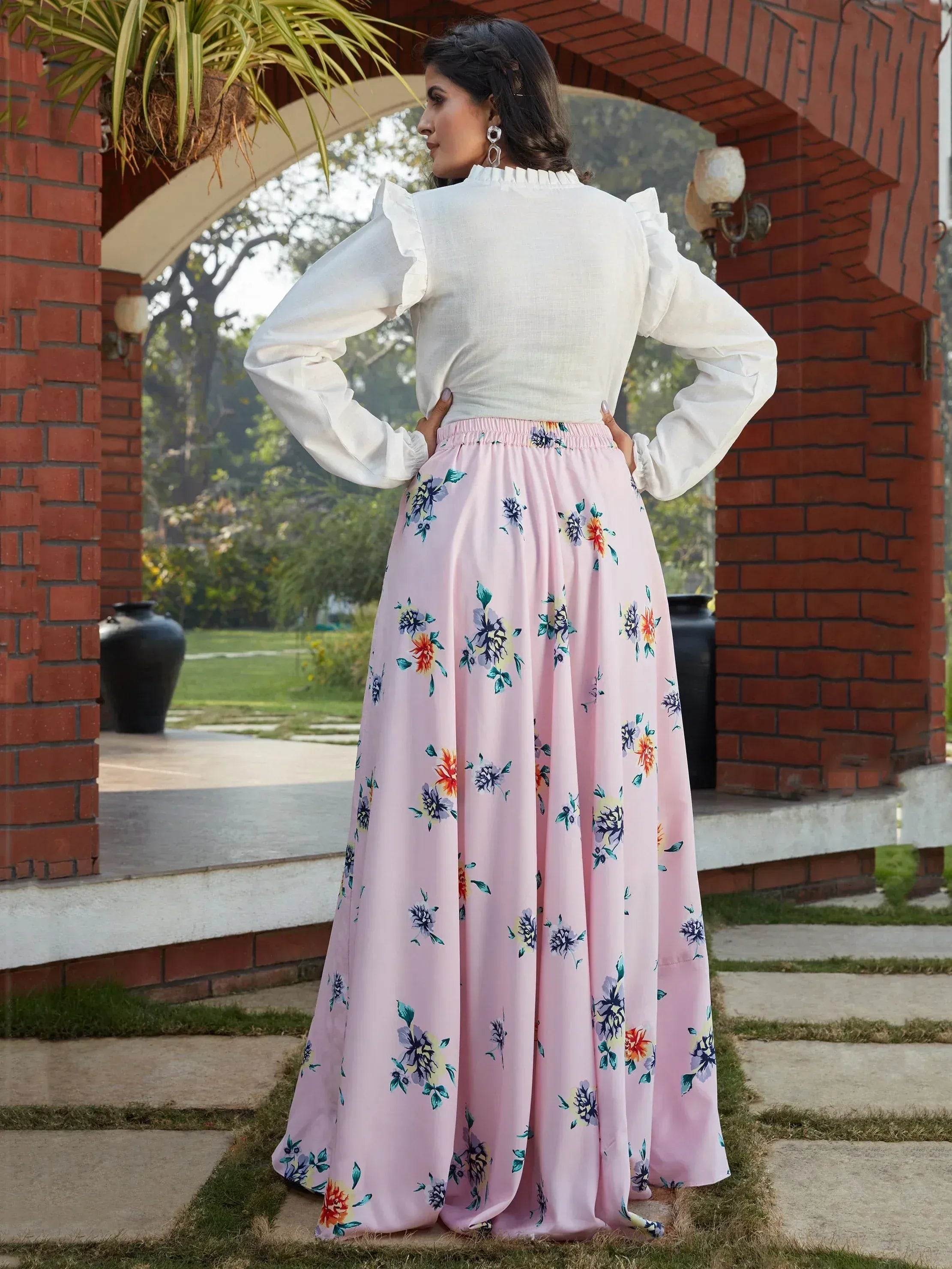 Woman in white ruffled top and pink floral skirt, ethnic wear for festive occasions