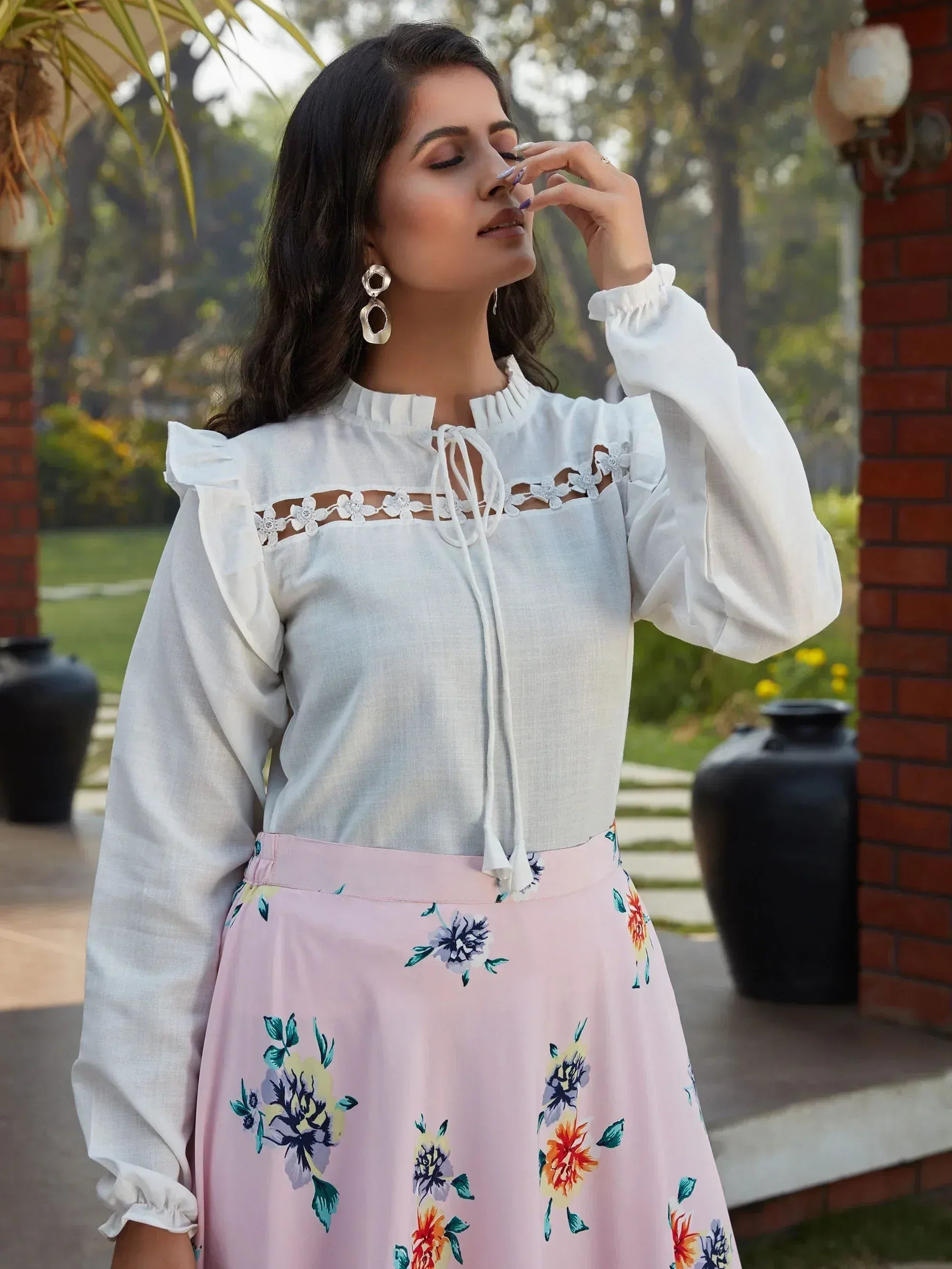 White ethnic top with lace detailing and pink floral skirt, perfect for Indian occasions