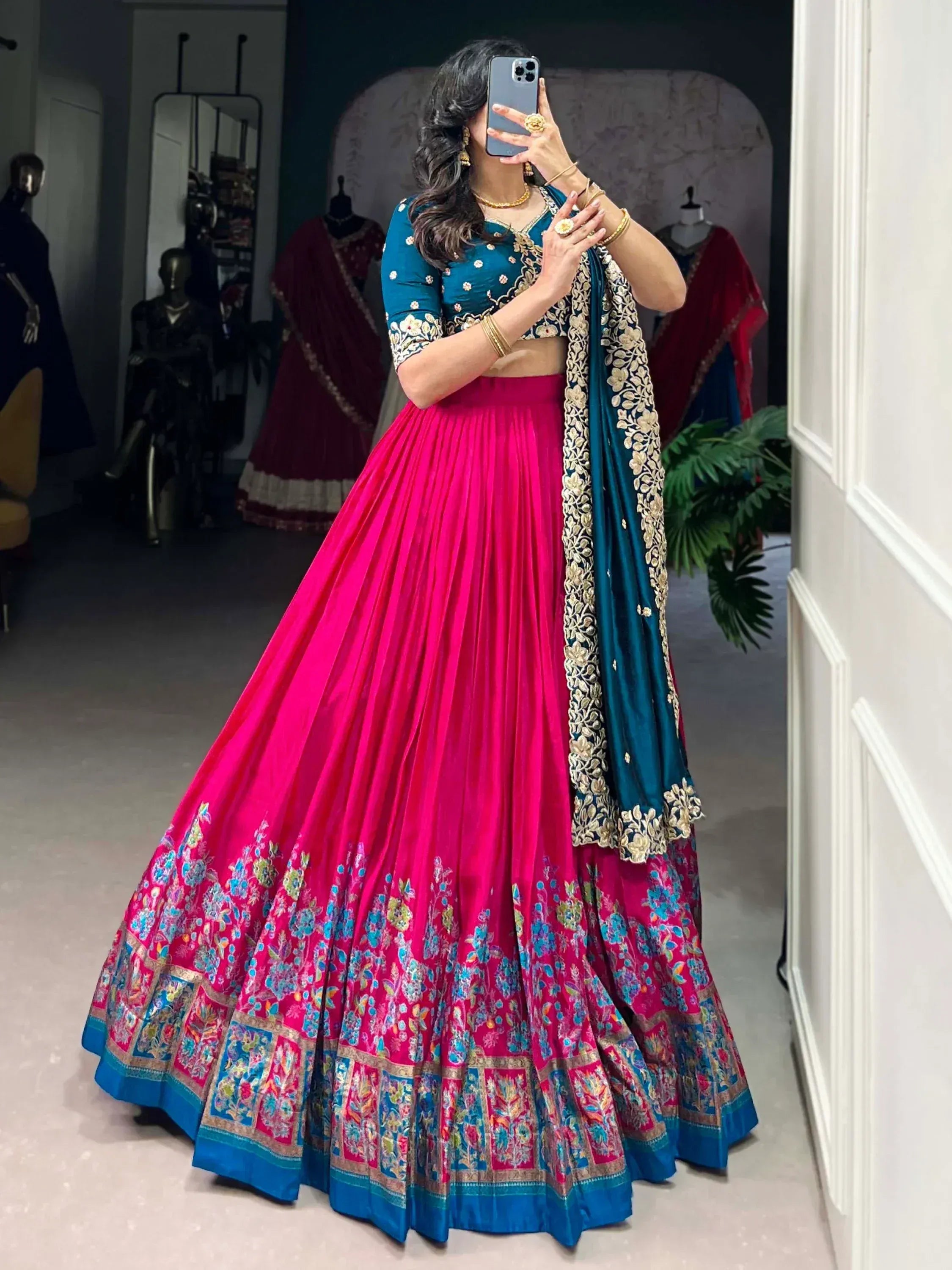 Vibrant pink and teal designer lehenga choli with floral embroidery, perfect for Indian ethnic wear occasions.