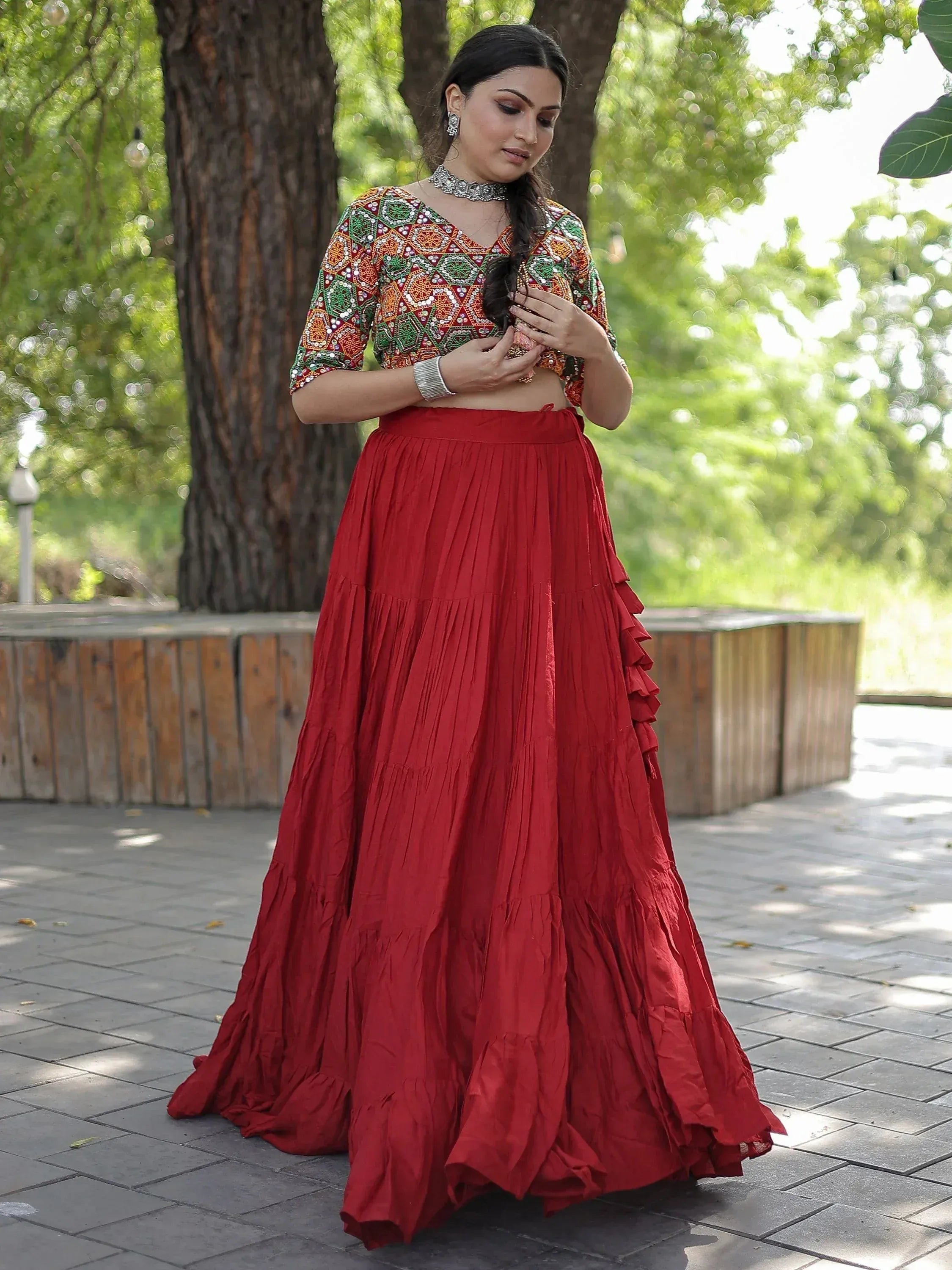 Woman in red pleated lehenga with embroidered crop top, ethnic Indian wear for festive occasions