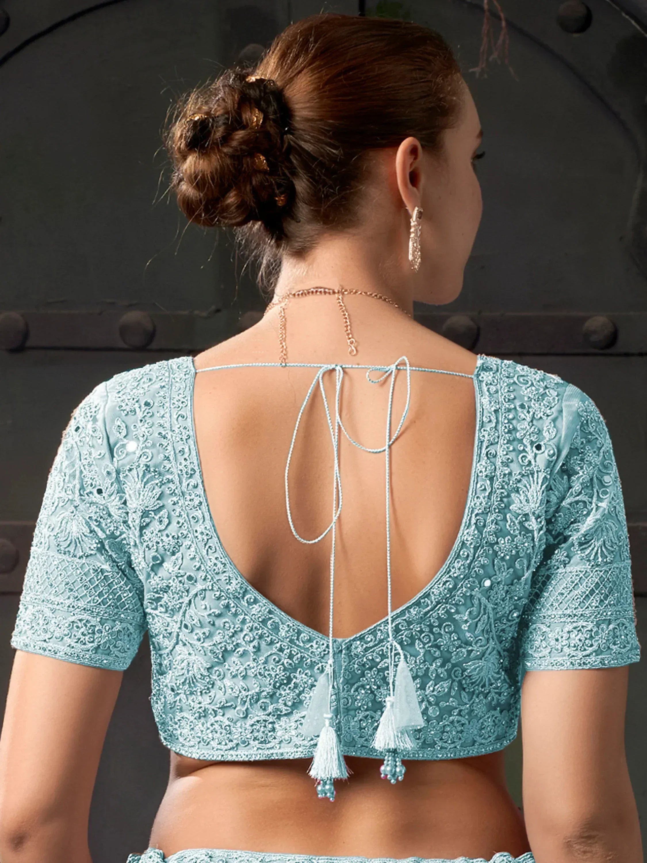 Light blue embroidered blouse with open back, tassels, and tie-up detail, perfect for Indian ethnic wear.
