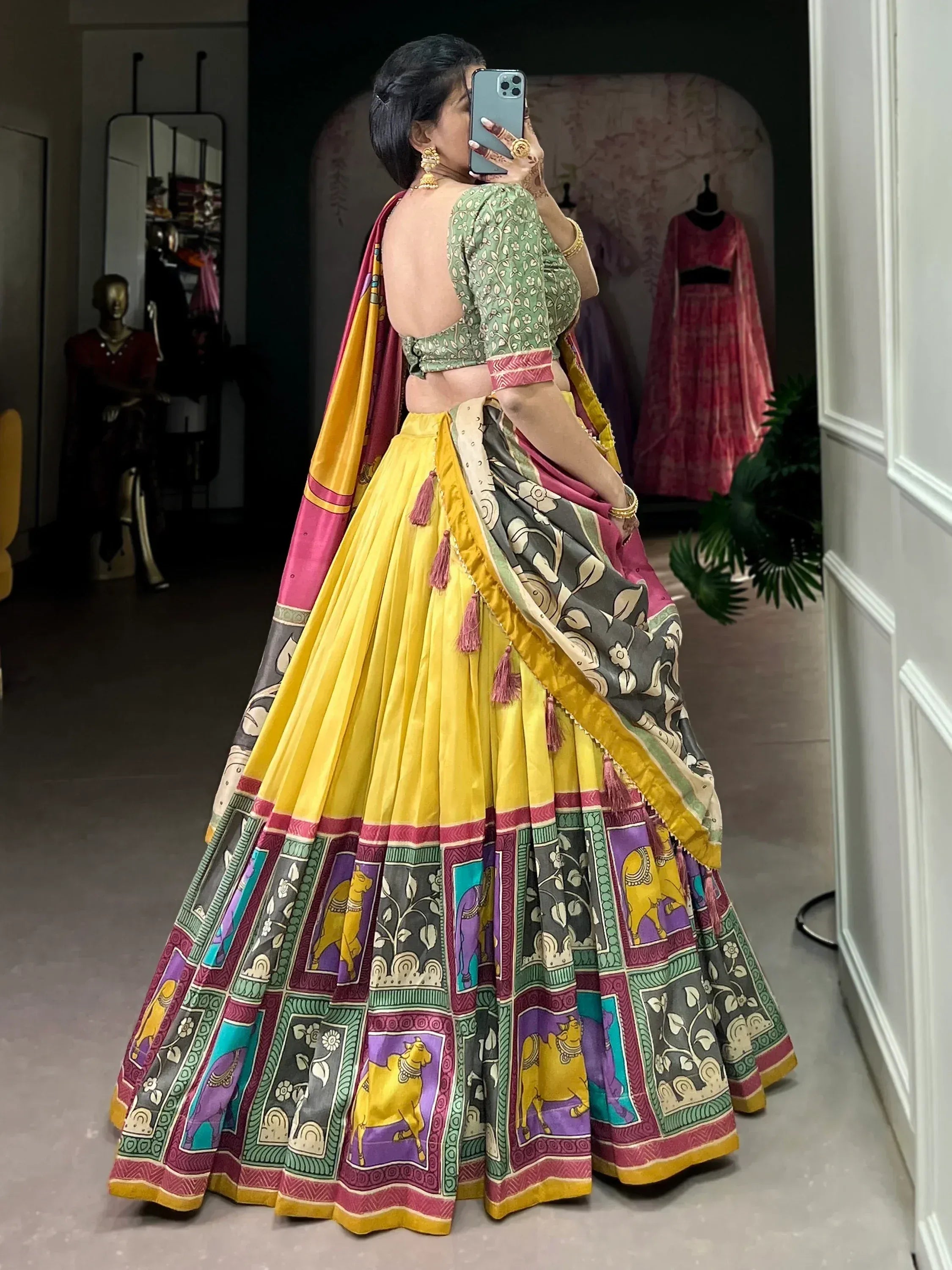 Woman in vibrant yellow lehenga choli with elephant print, perfect for Indian ethnic wear occasions