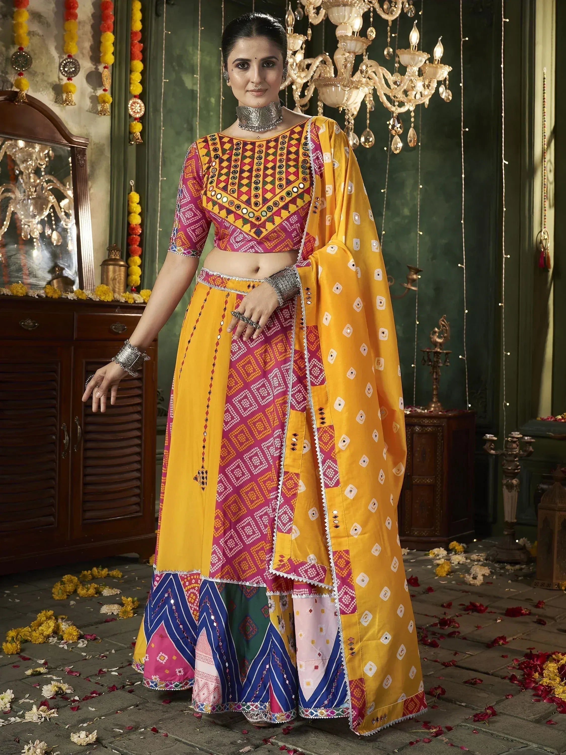 Vibrant yellow and pink mirror-work lehenga choli with ethnic print, perfect for festive occasions.