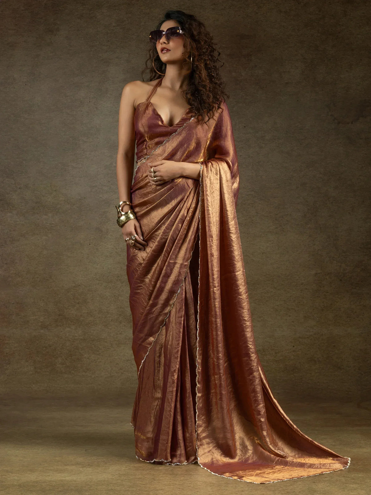Elegant bronze saree with shimmering texture and delicate border, styled with halter neck blouse for ethnic wear