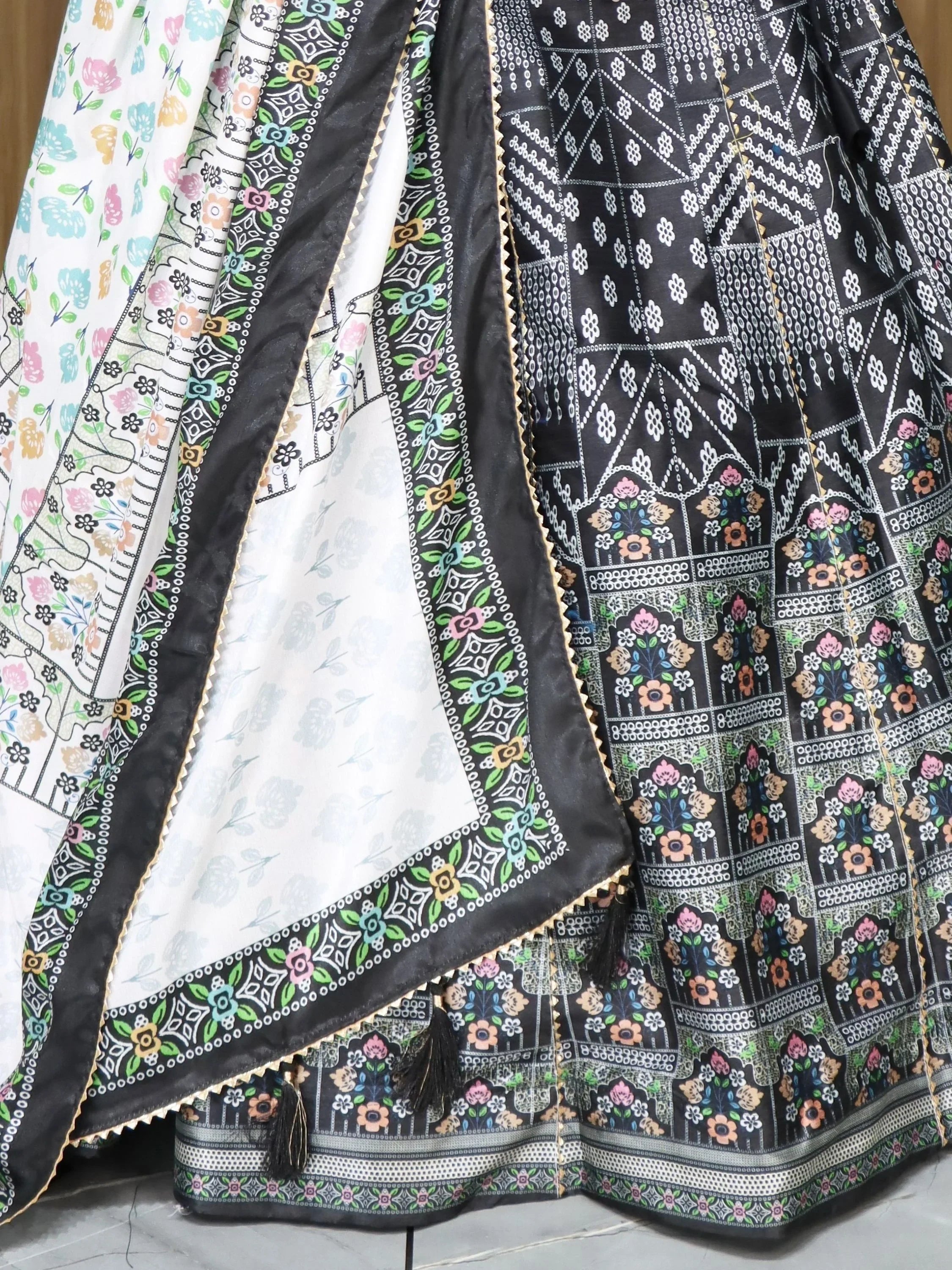 Black and white floral printed ethnic lehenga with colorful border and tassels, perfect for Indian weddings and festivals