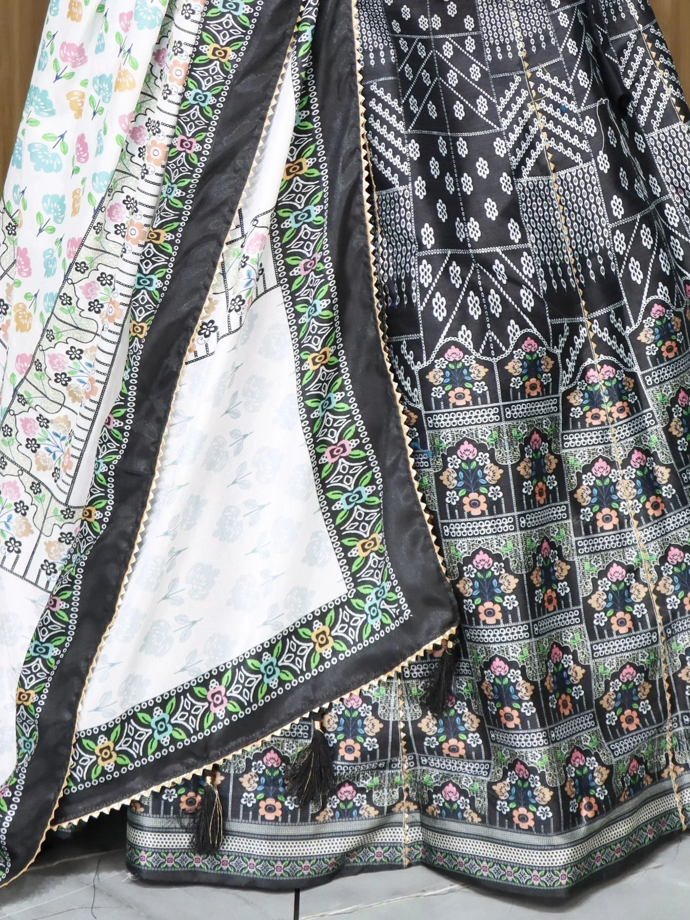 Black and white floral printed ethnic lehenga with colorful border and tassels, perfect for Indian weddings and festivals
