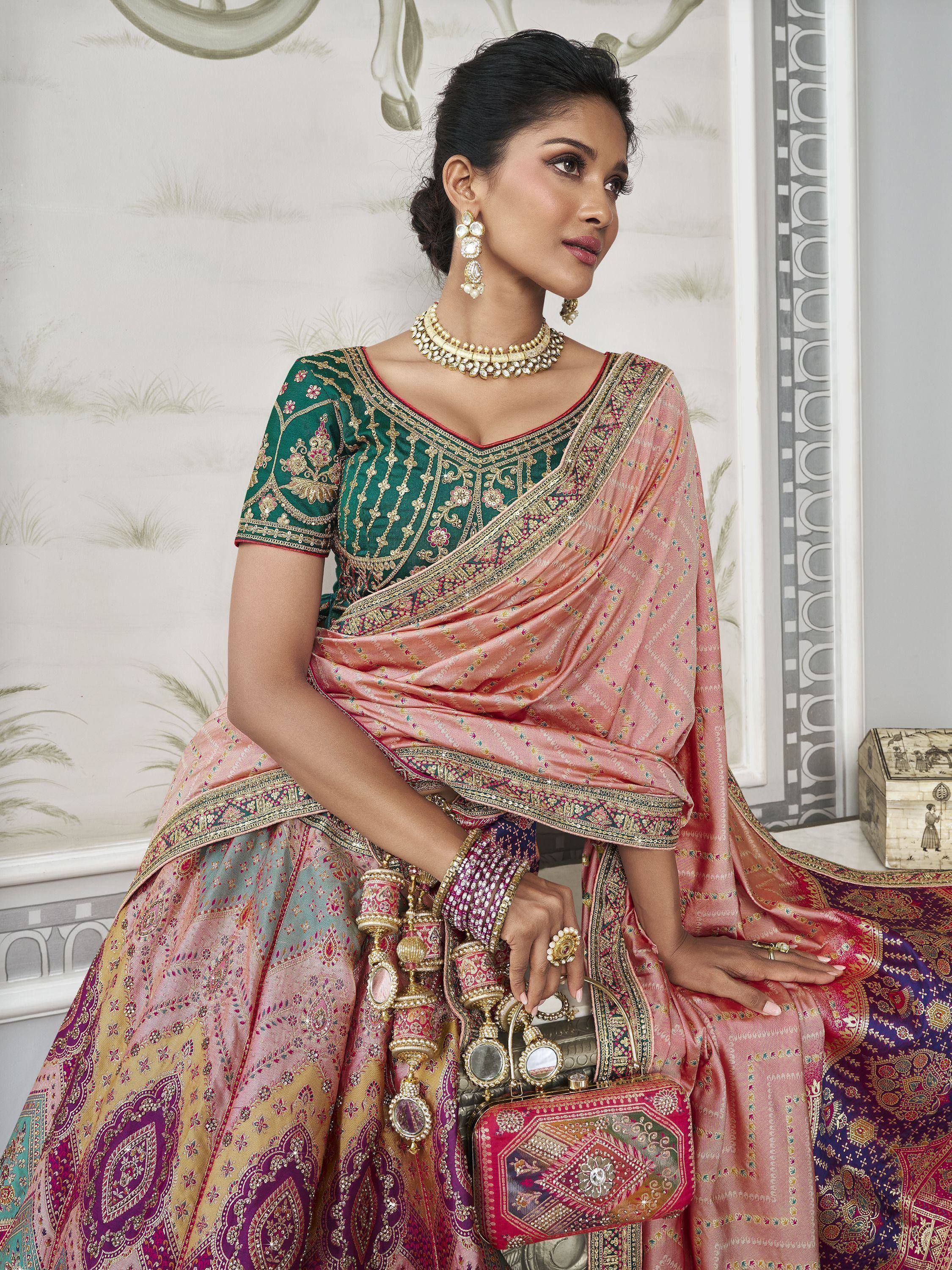 Elegant Indian ethnic wear: pink and green embroidered lehenga choli with traditional jewelry and clutch