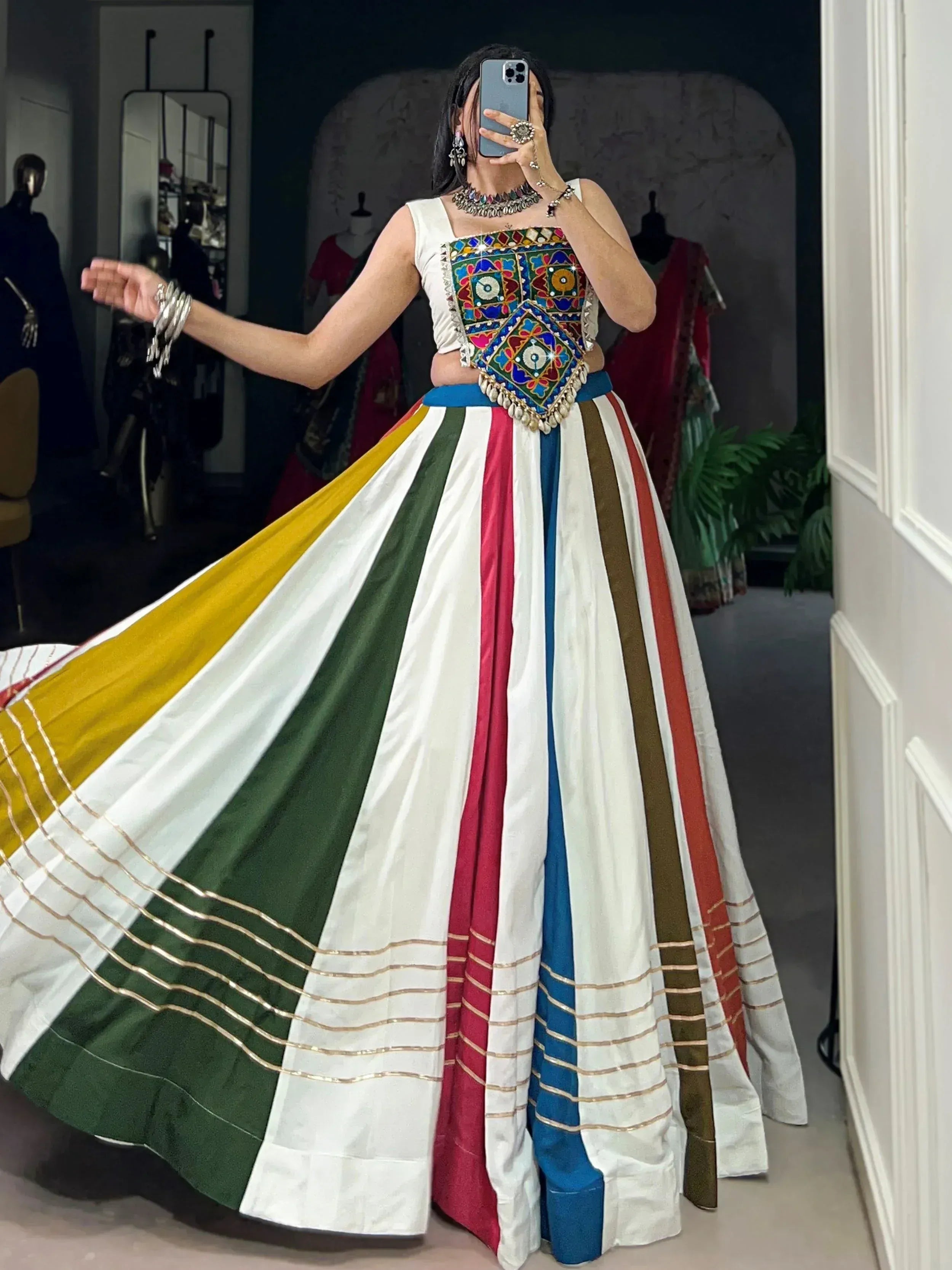 Woman in colorful striped lehenga with embroidered mirror work top, traditional Indian ethnic wear