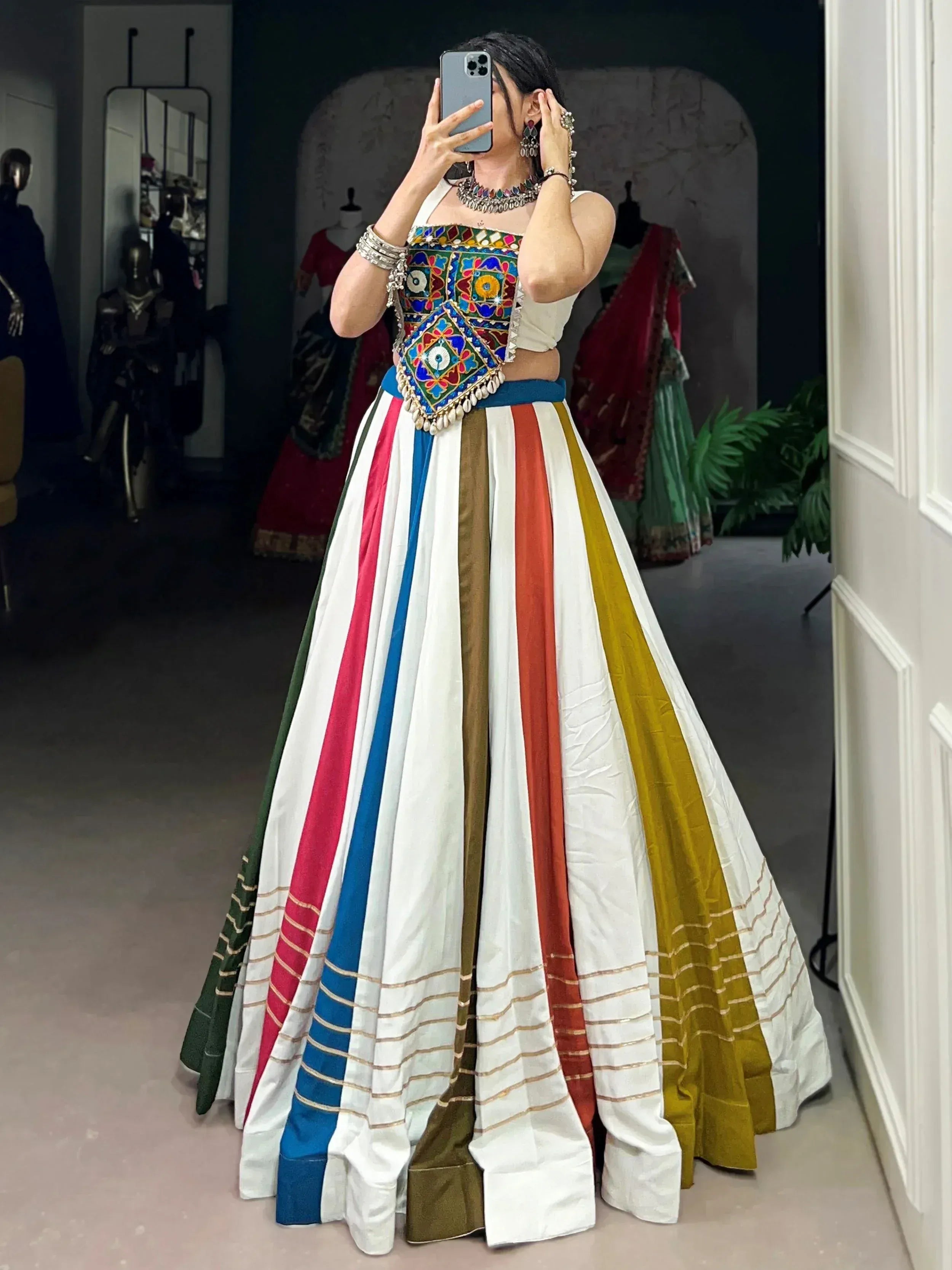 Woman in colorful striped lehenga with embroidered blouse, perfect for Indian ethnic wear occasions.