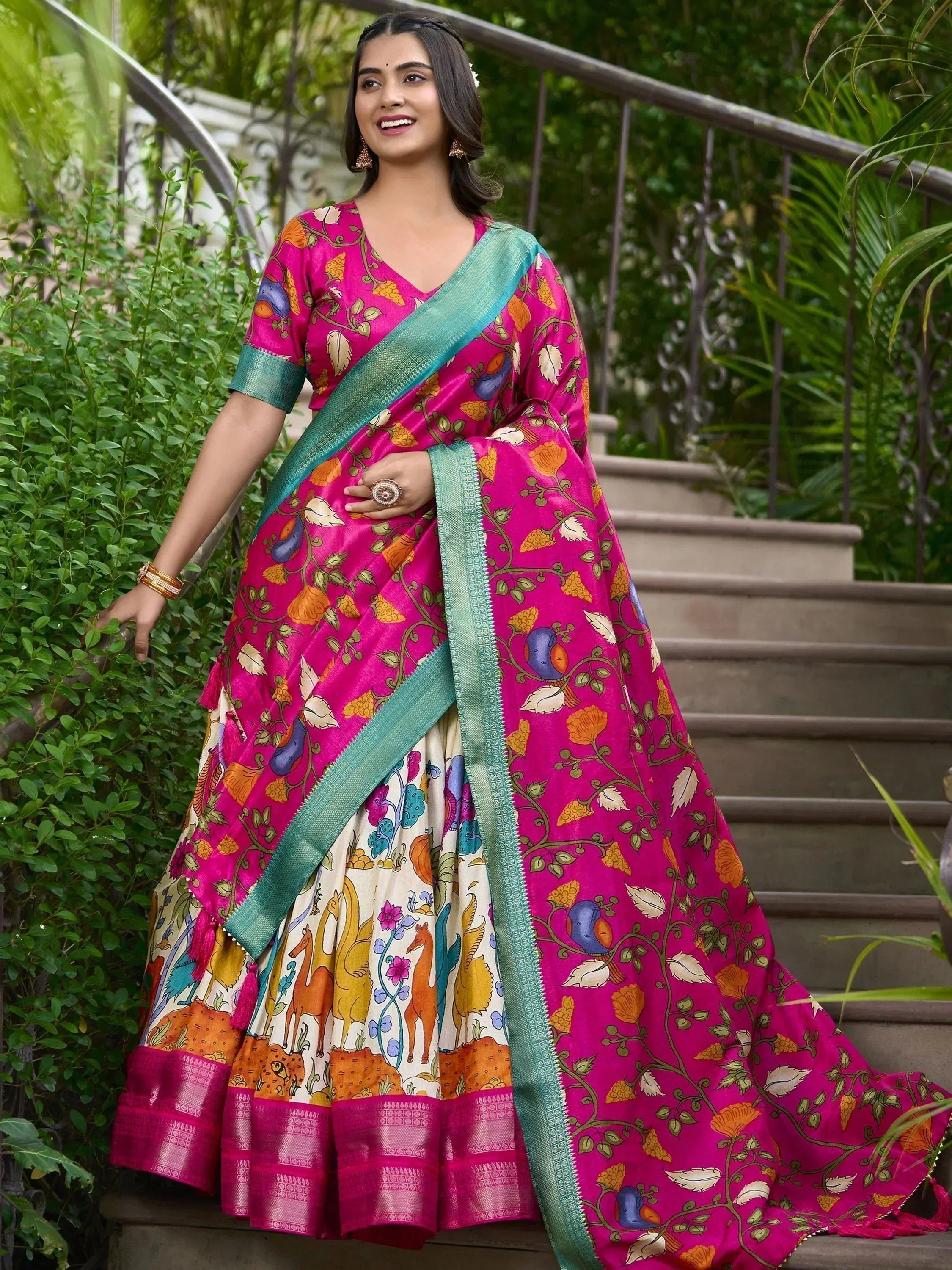 Vibrant pink printed lehenga choli with teal border, floral and bird motifs, perfect for ethnic occasions