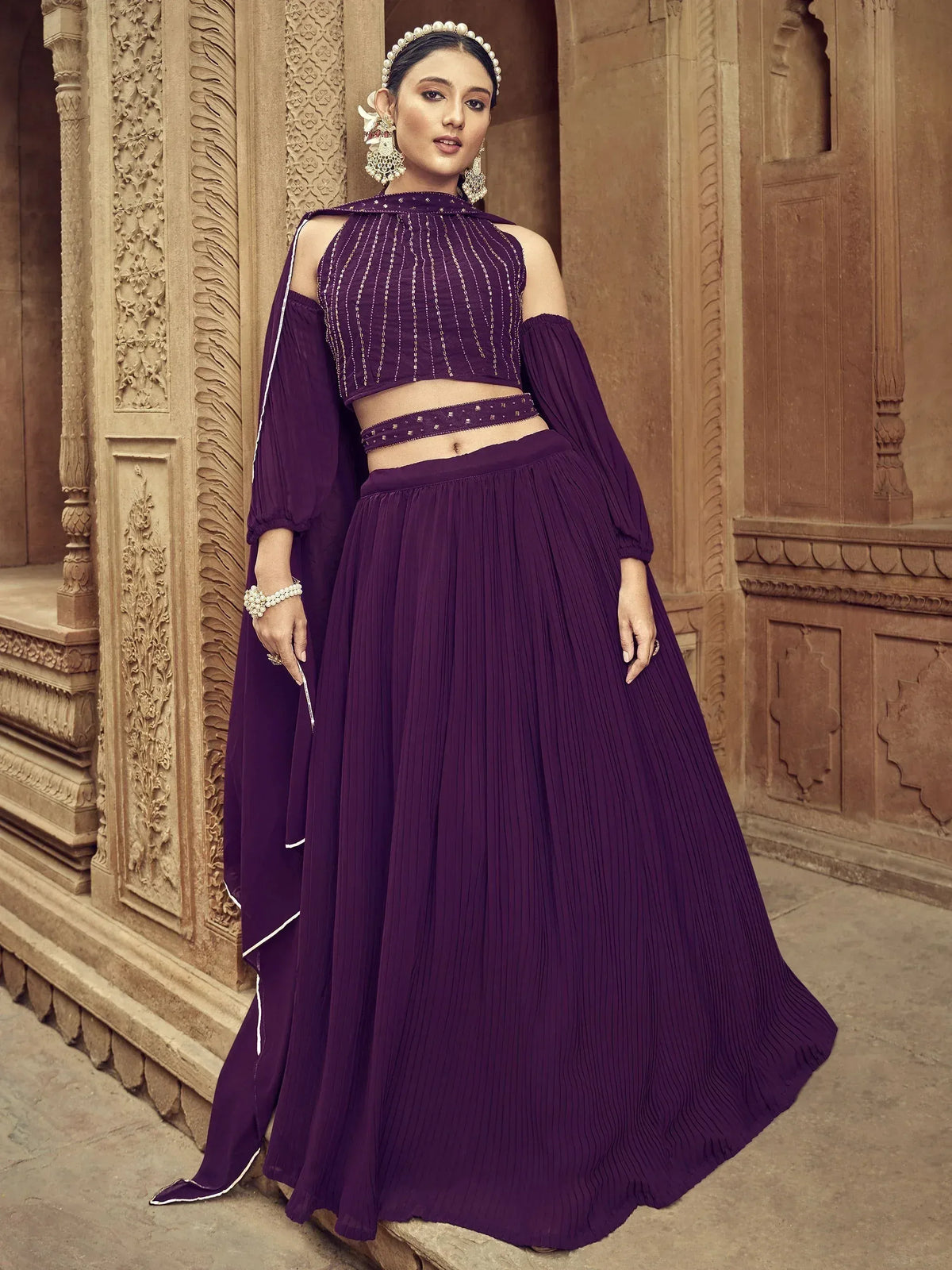 Purple ethnic lehenga choli with pleated skirt and embellished crop top, perfect for Indian weddings or festive occasions.