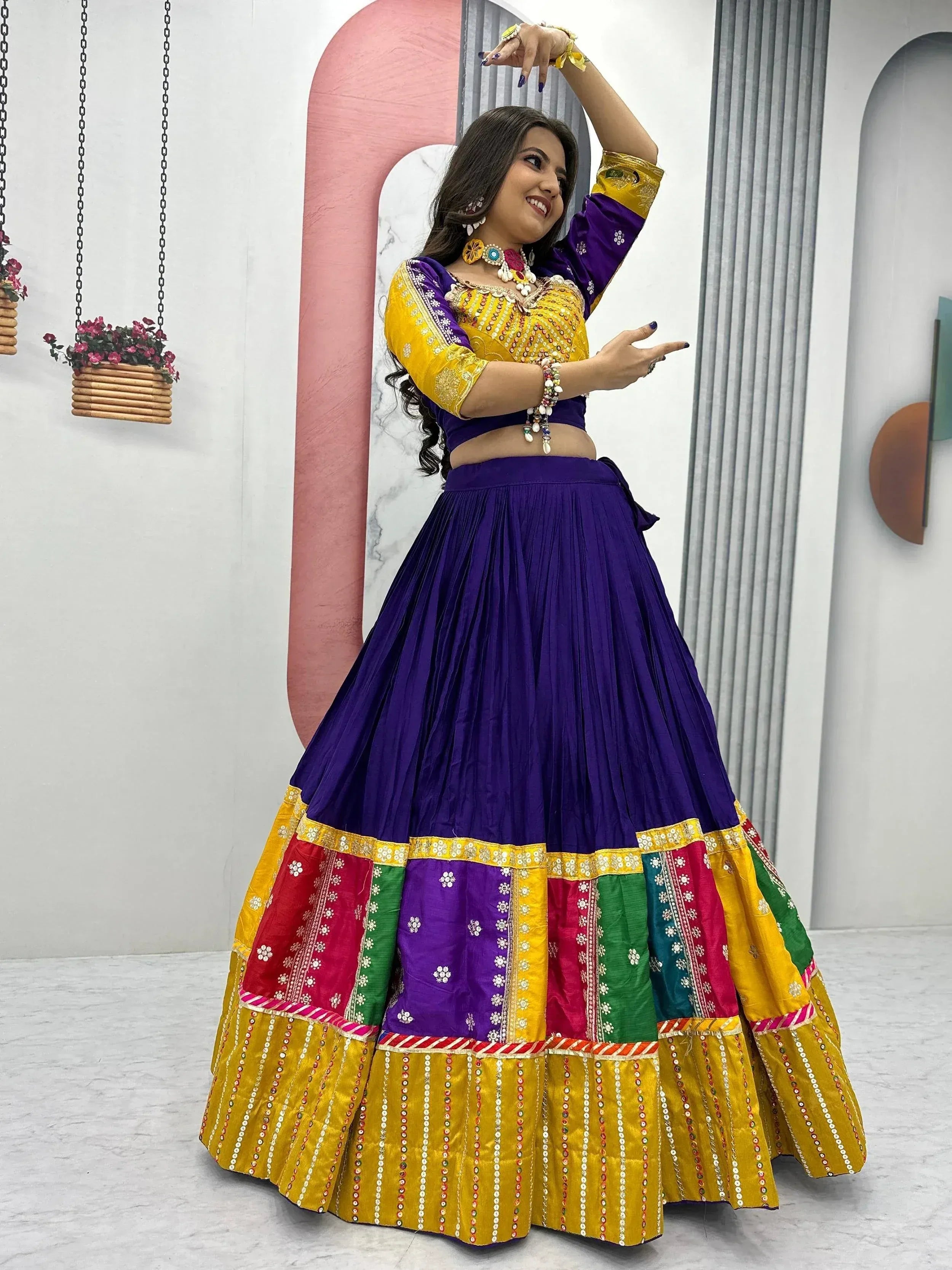 Woman in vibrant purple and yellow lehenga choli with colorful patchwork skirt, perfect for Indian ethnic occasions