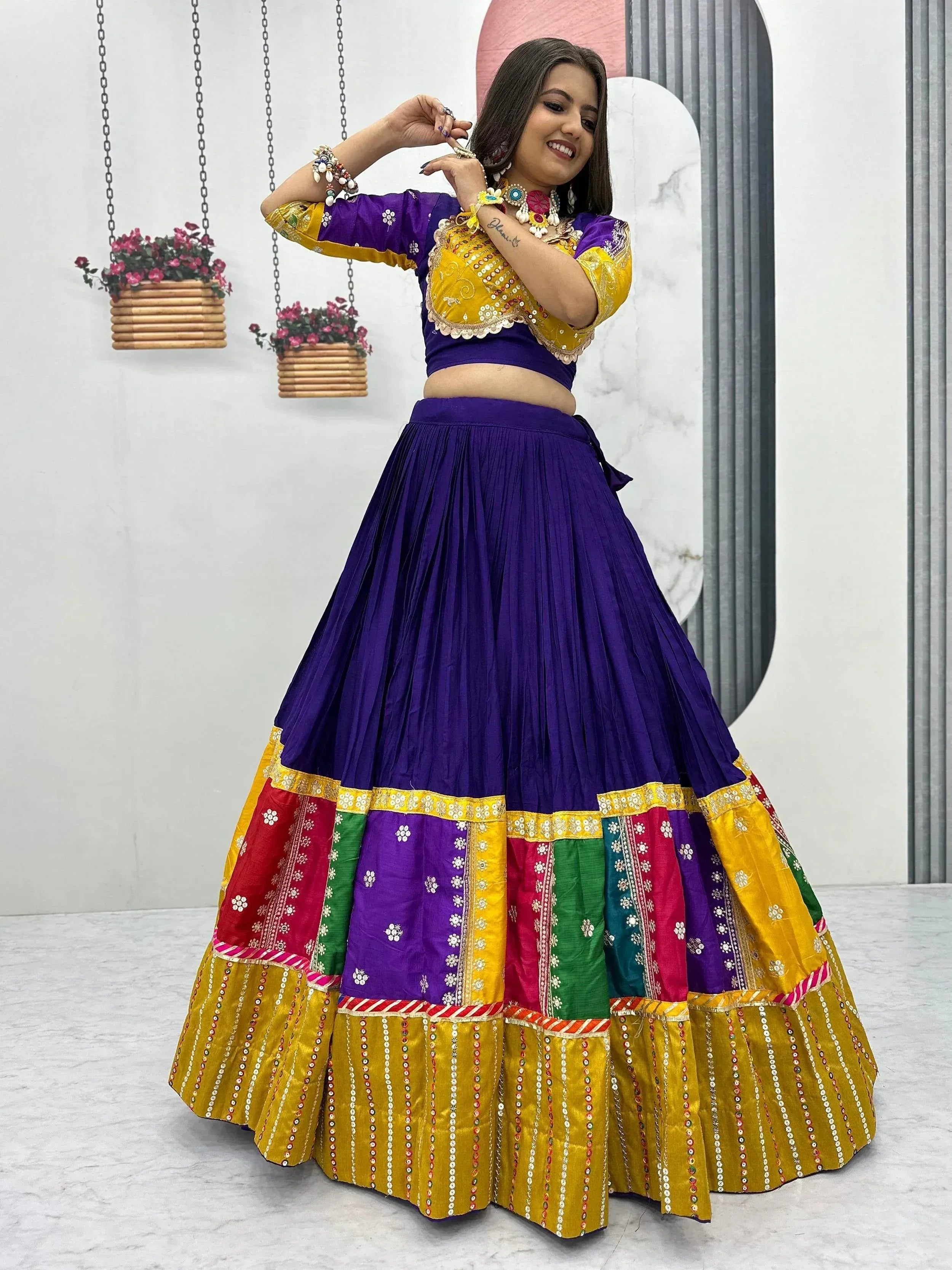 Vibrant purple and yellow Indian lehenga choli with colorful patchwork skirt and mirror work, perfect for festive occasions.