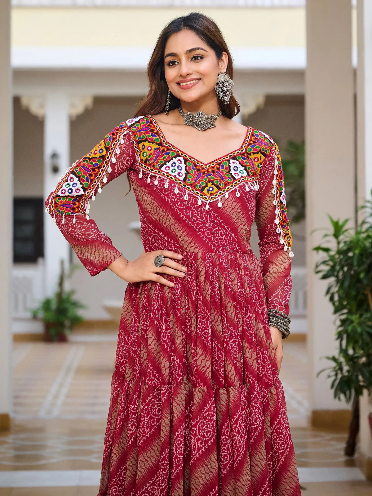 Red ethnic gown with colorful mirror work and embroidery, perfect for Indian occasions