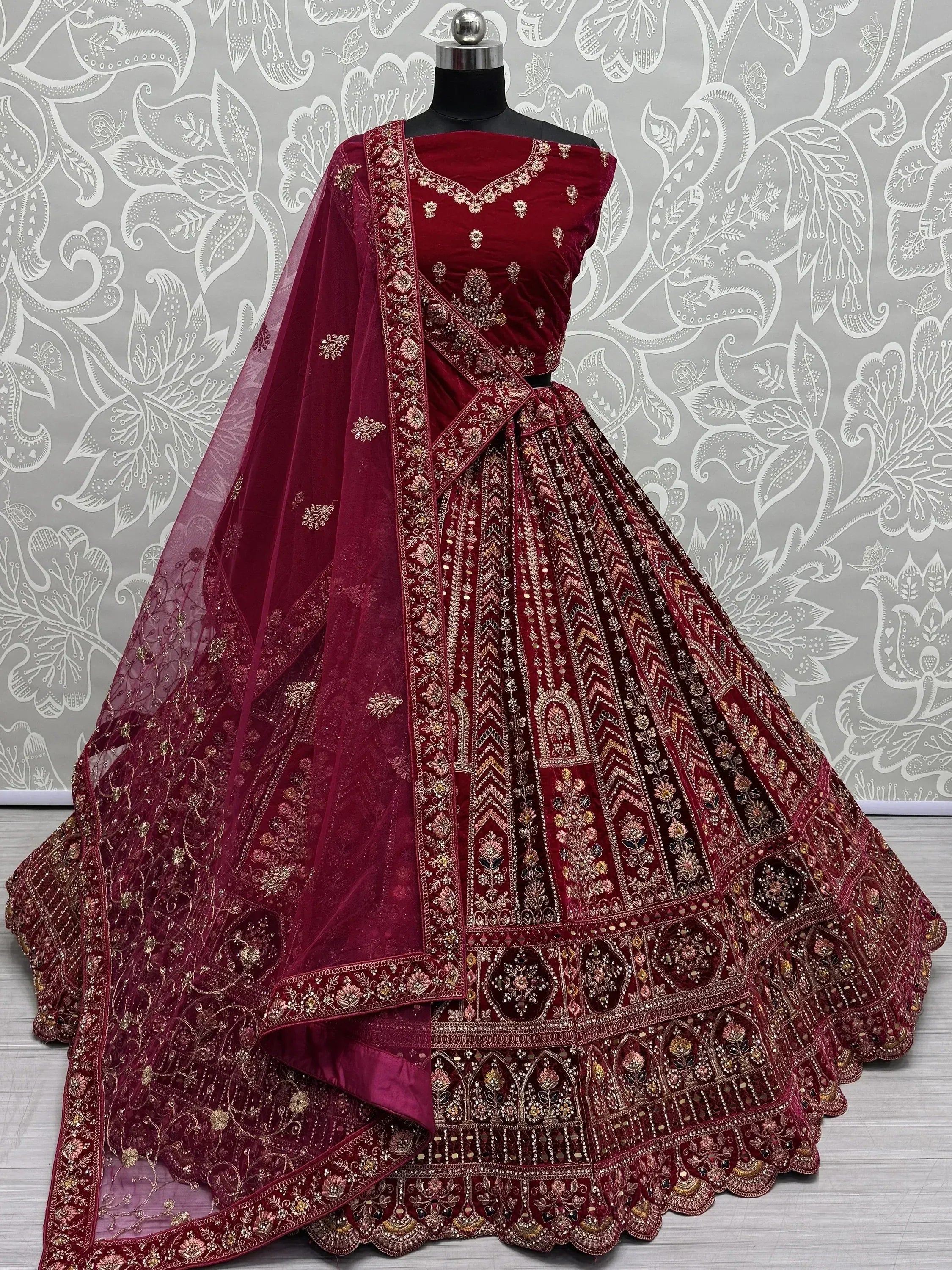 Maroon velvet designer lehenga choli with heavy gold embroidery and matching dupatta, perfect for weddings