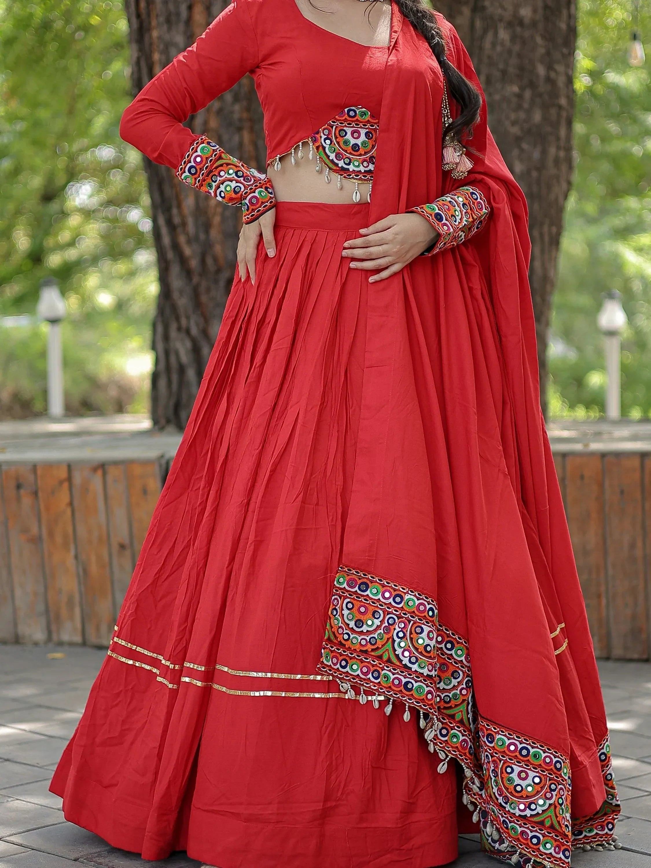Red ethnic lehenga choli with colorful mirror work and embroidery, perfect for Indian festivals and weddings