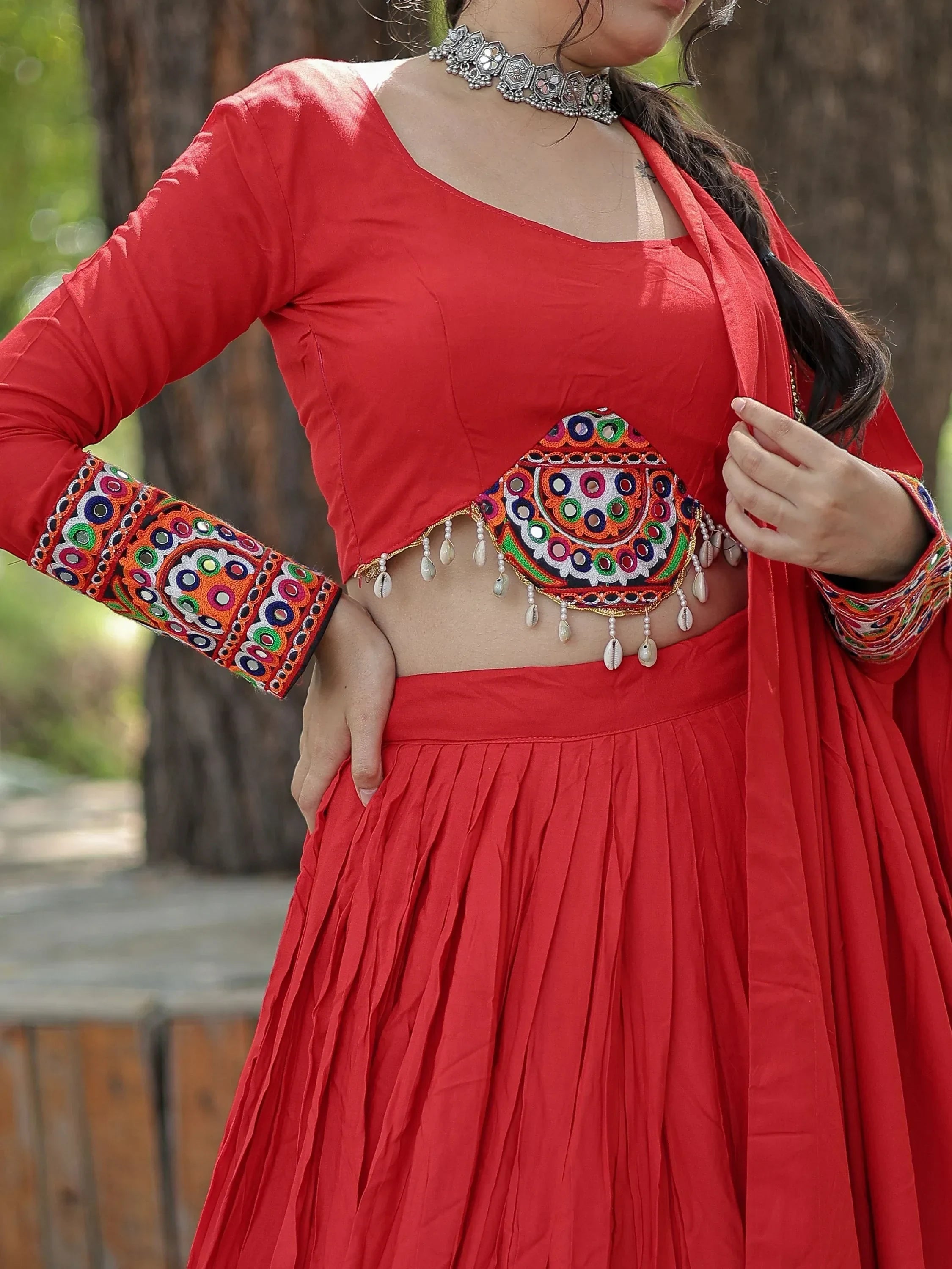 Red ethnic lehenga choli with mirror work, embroidery, and shell detailing for festive occasions