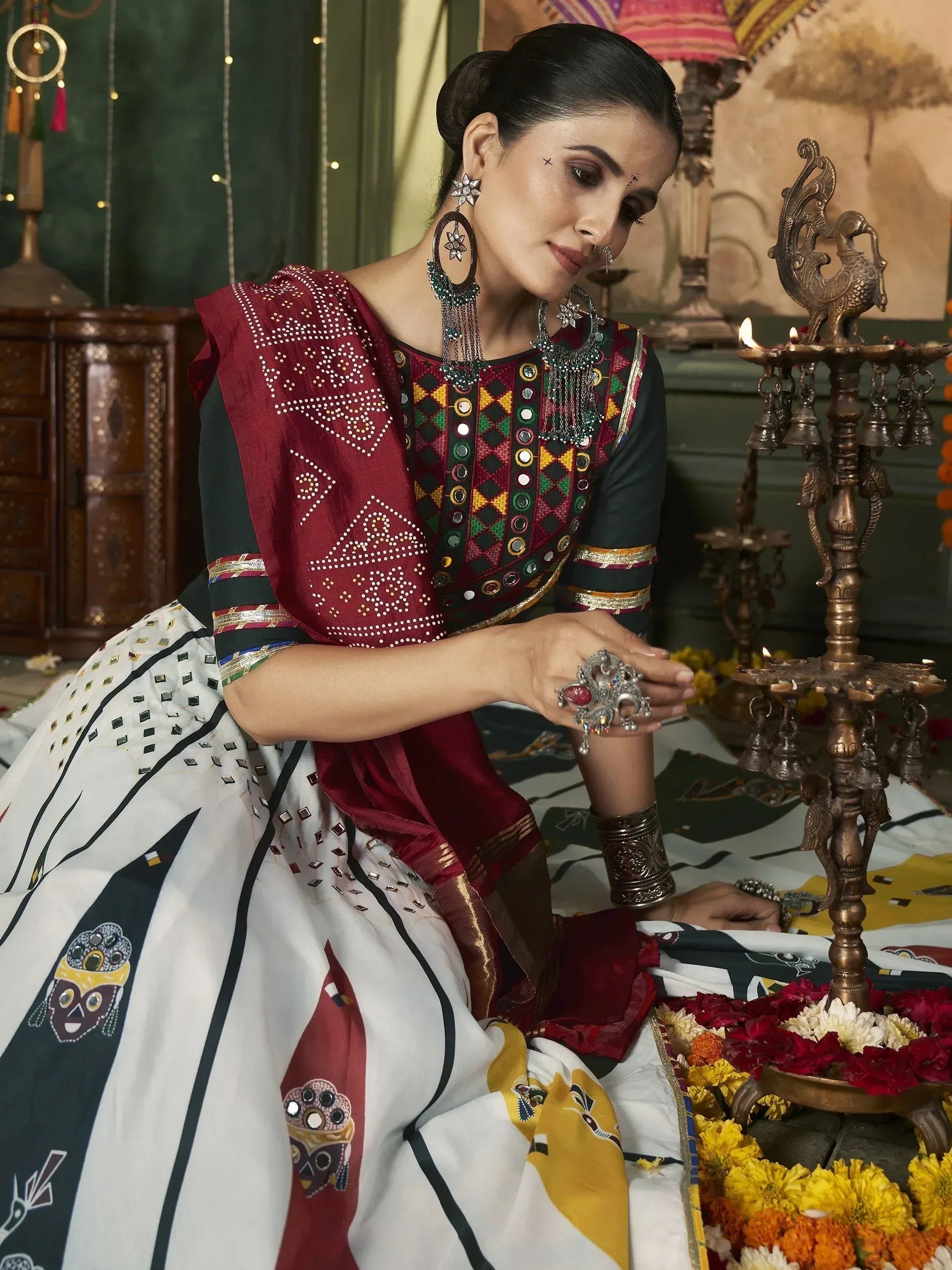 Woman in traditional Indian ethnic wear with mirror work, floral patterns, and festive jewelry for celebrations.