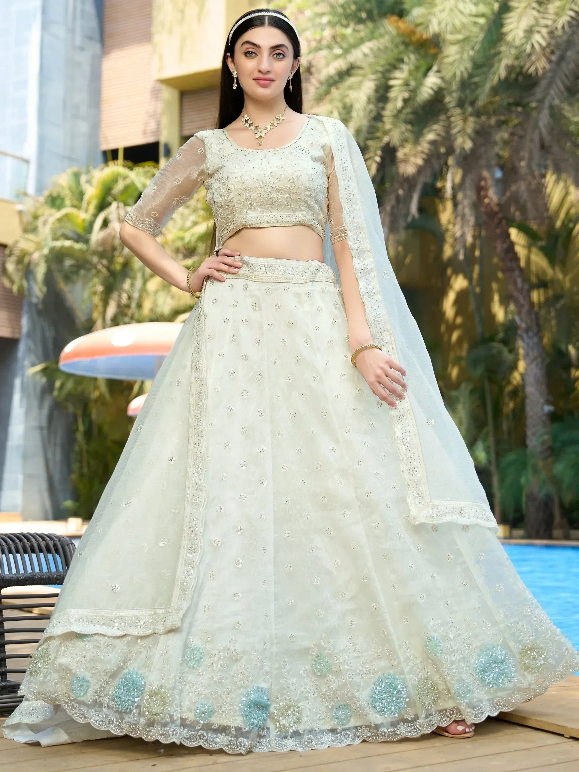 Elegant off-white lehenga choli with floral embroidery, perfect for Indian weddings and festive occasions.