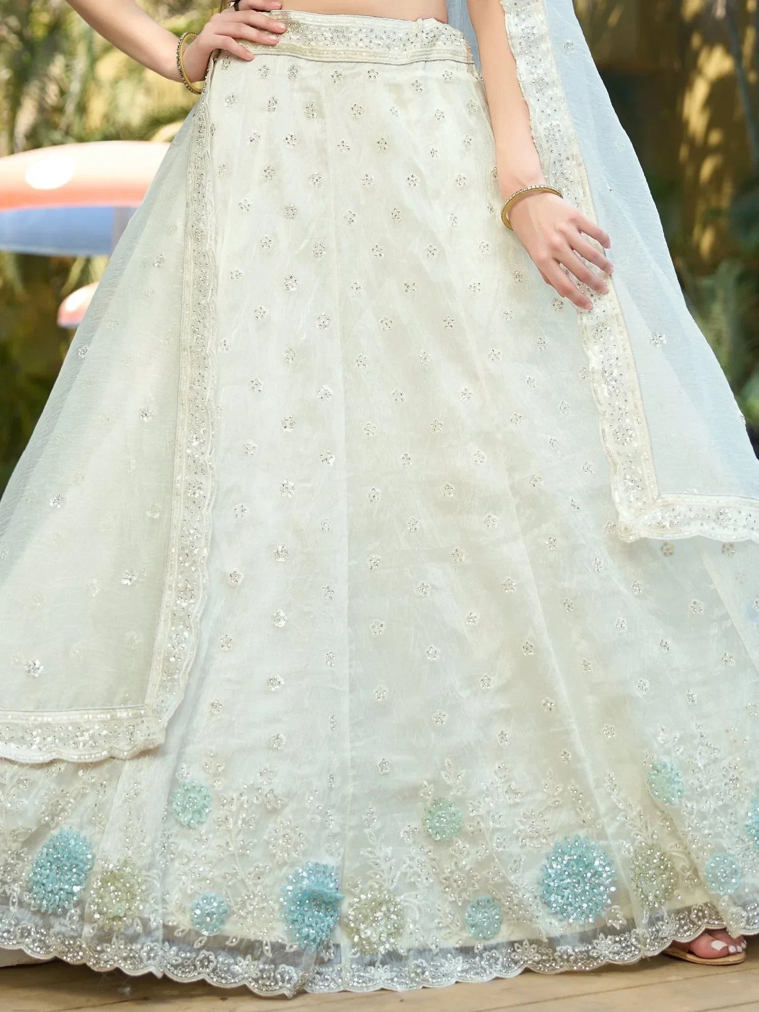 Elegant white lehenga with floral embroidery and light blue accents, perfect for Indian ethnic wear