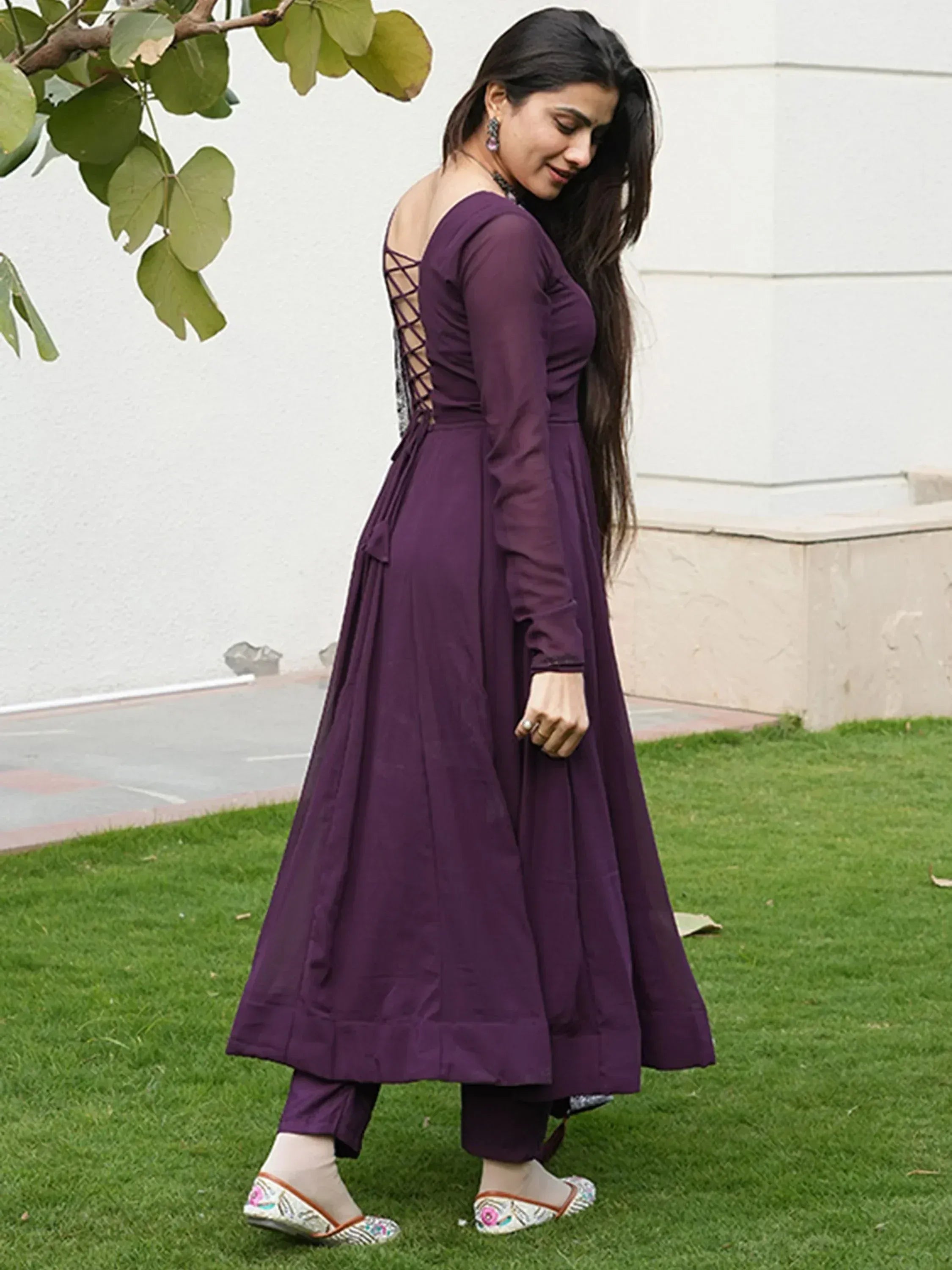 Purple ethnic gown with lace-up back, paired with matching pants and embroidered flats for Indian wear