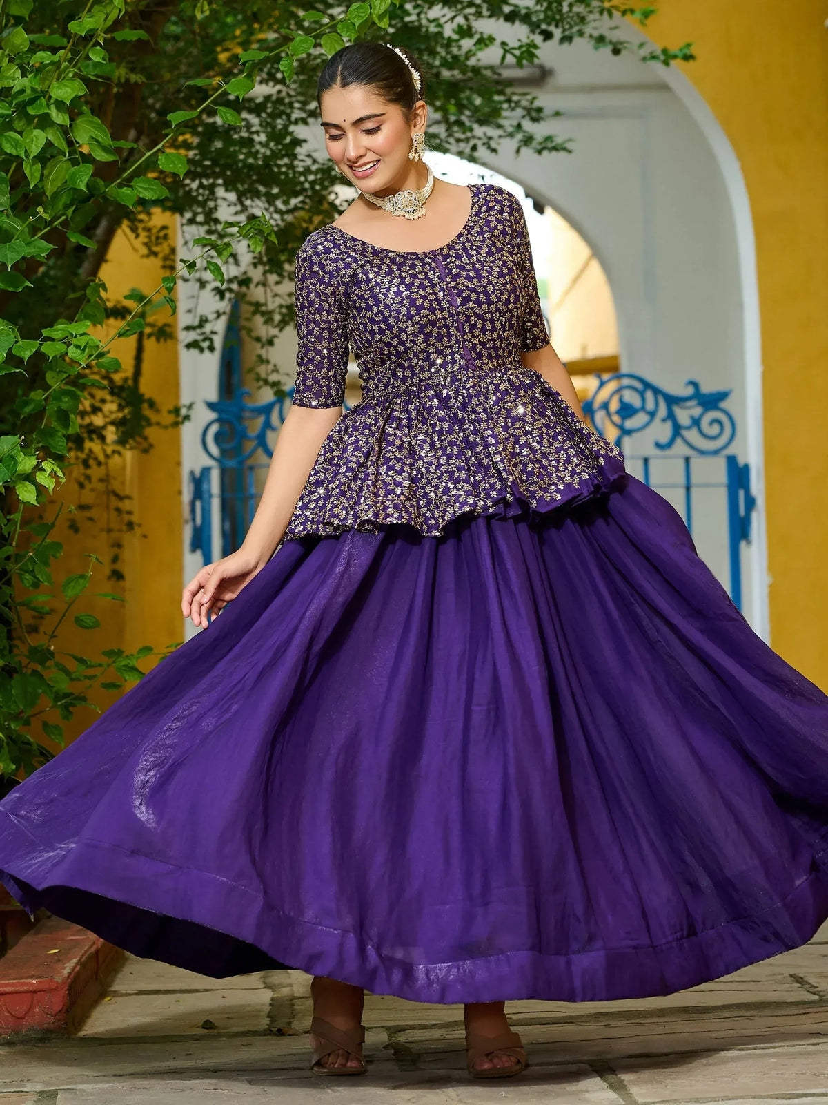Purple ethnic gown with gold floral embroidery, perfect for Indian celebrations and festive occasions.