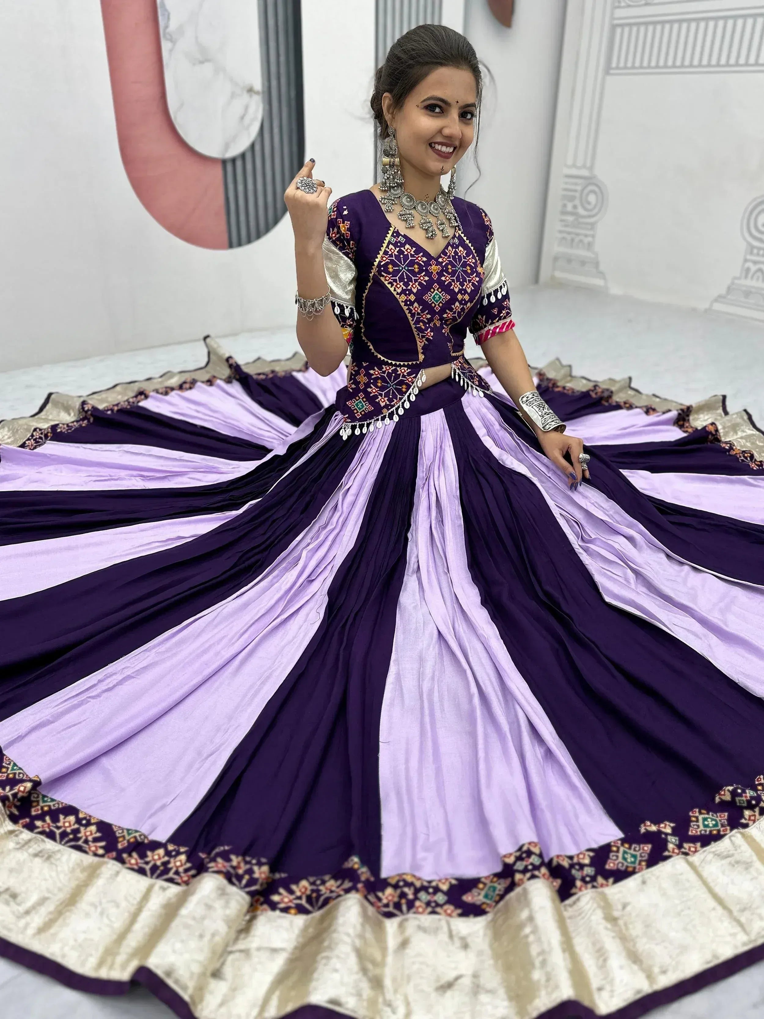 Woman in purple and lavender ethnic lehenga choli with mirror work and silver jewelry