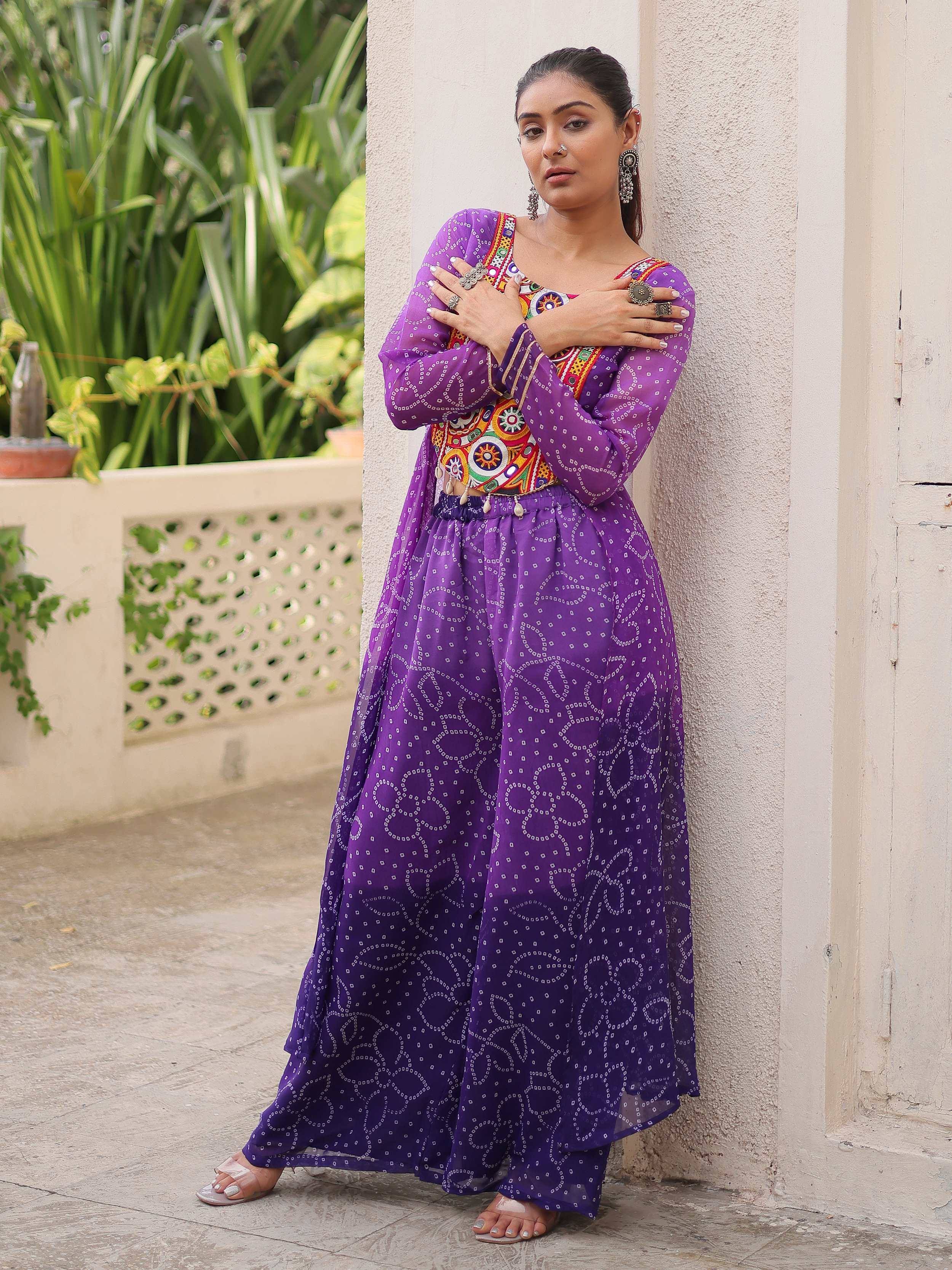 Purple ethnic gown with intricate embroidery and mirror work, perfect for Indian festive occasions.