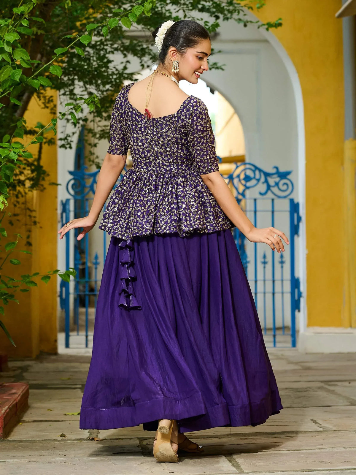 Purple ethnic gown with gold embroidery and ruffled skirt, perfect for Indian occasions