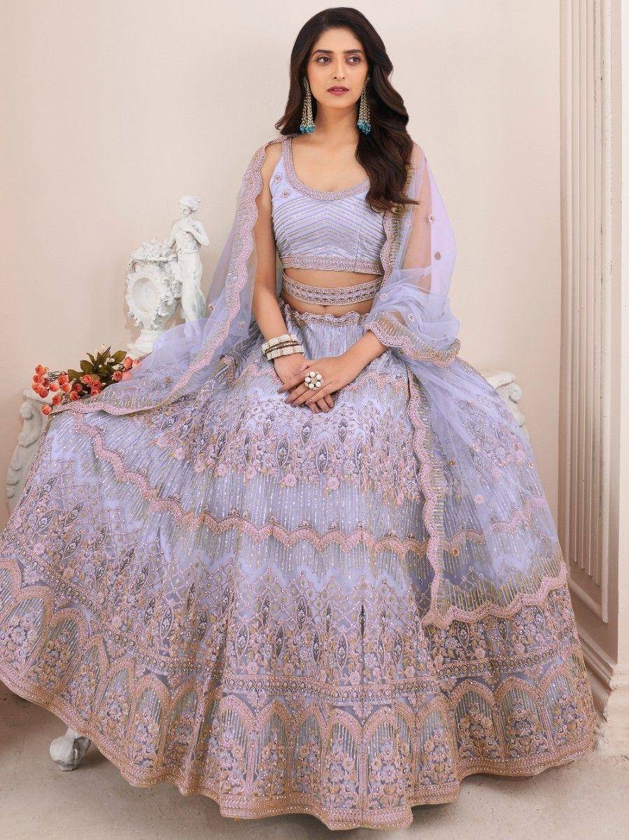 Elegant lavender lehenga choli with intricate gold embroidery and sheer dupatta, perfect for Indian weddings or festive occasions.