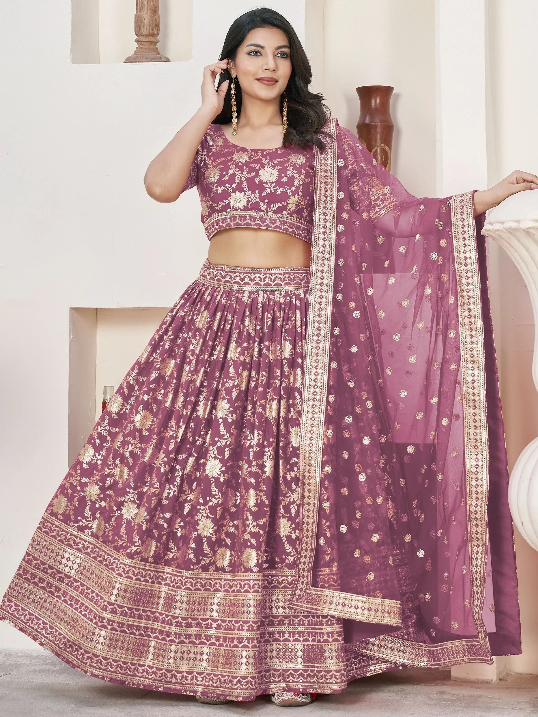 Elegant maroon lehenga choli with gold floral embroidery and sheer dupatta, perfect for Indian ethnic occasions.