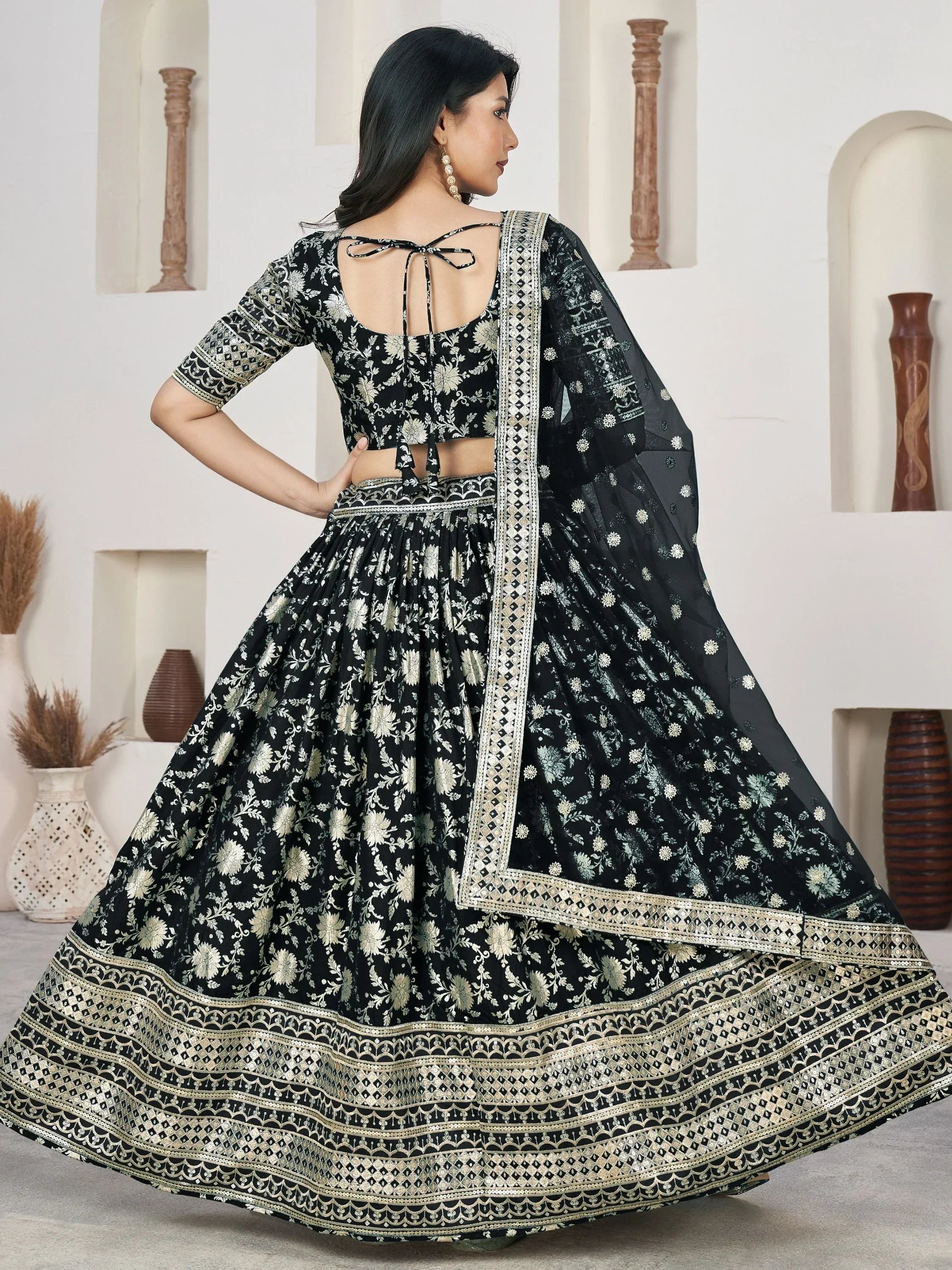 Black and gold embroidered lehenga choli with floral print and tie-back blouse, perfect for Indian ethnic wear.